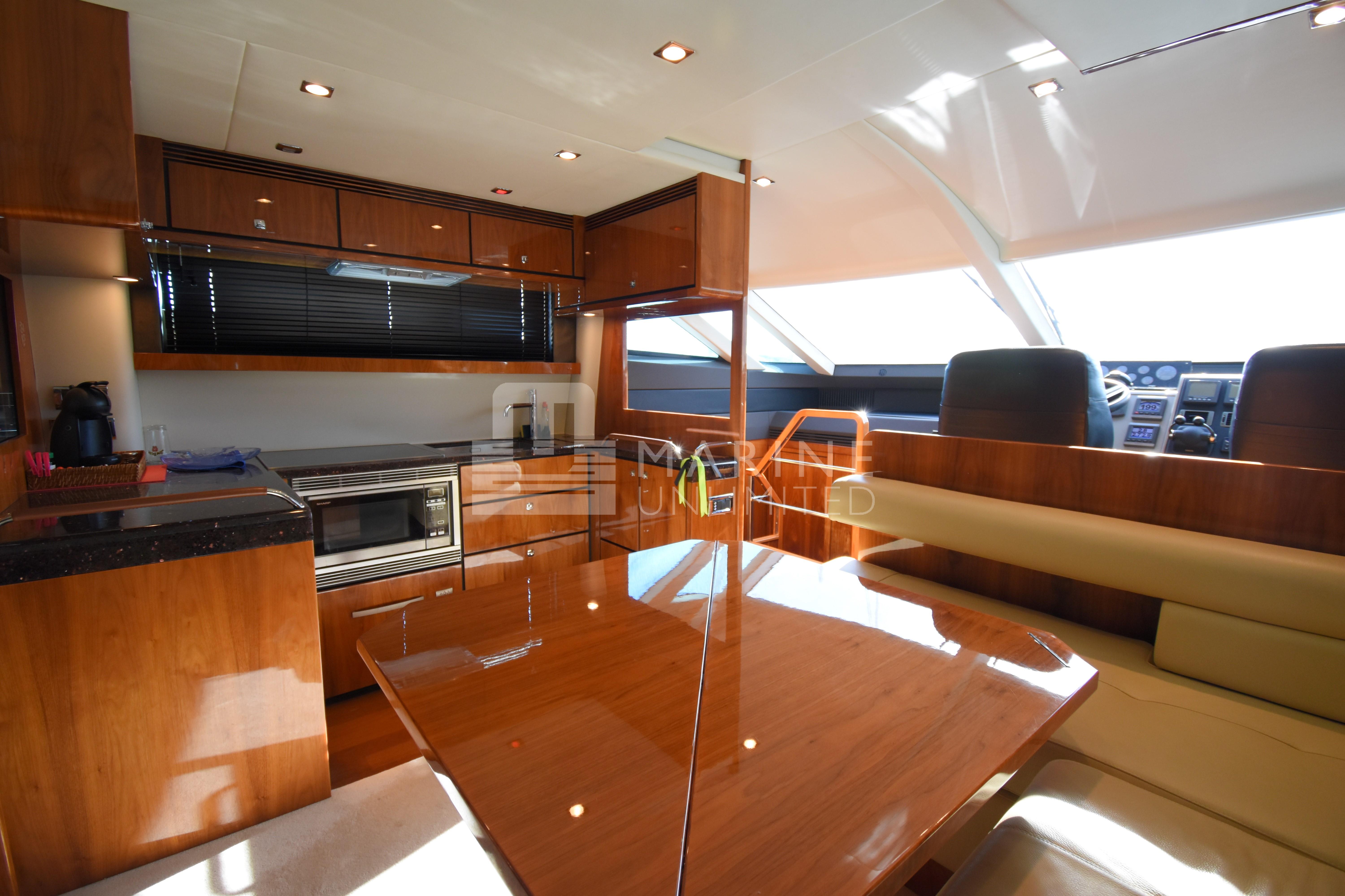 Luxurious interior of 2010 Fairline Squadron 55 yacht with modern kitchen and dining area.