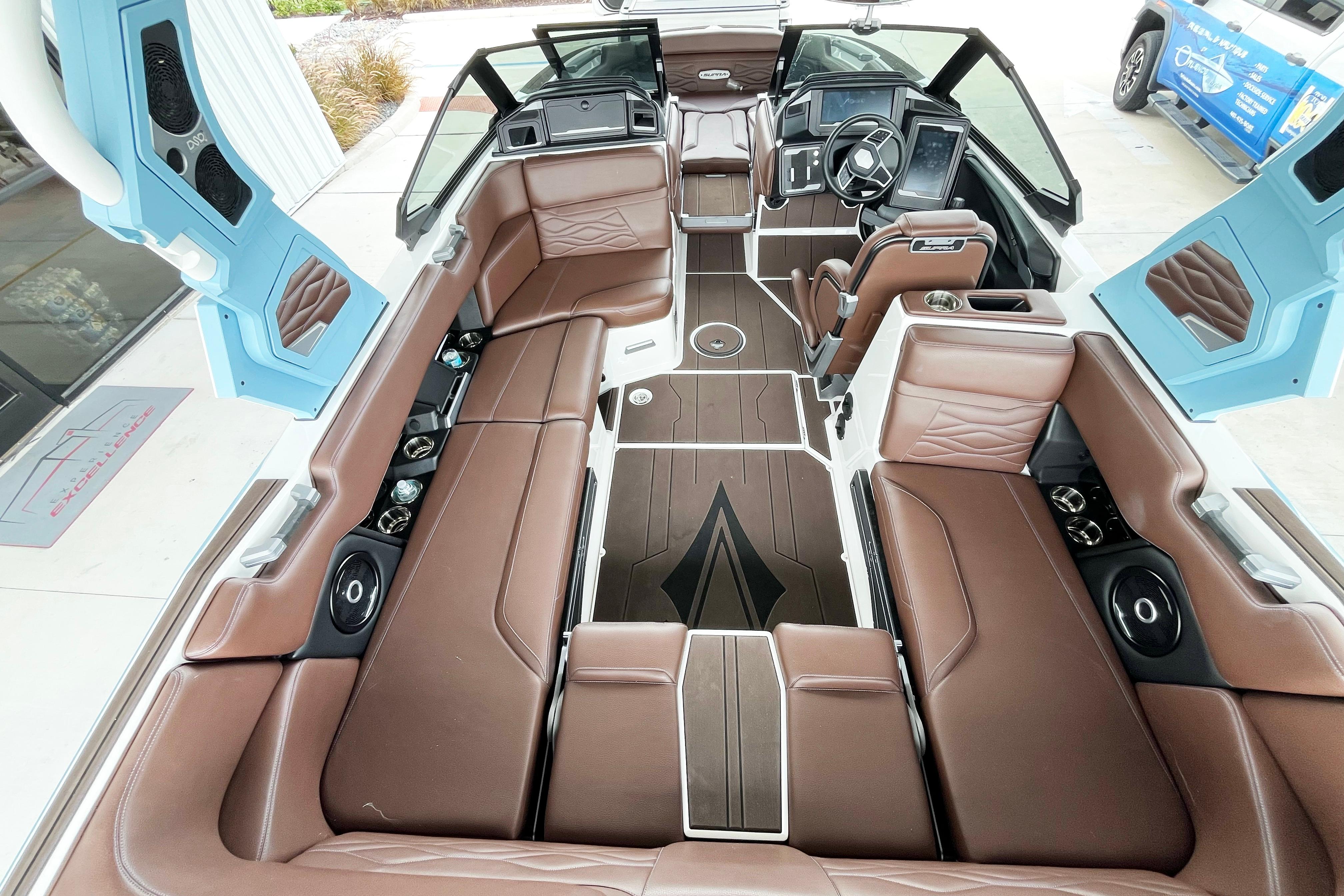 Luxurious interior of 2025 Supra SA450 boat with brown seating and modern dashboard.