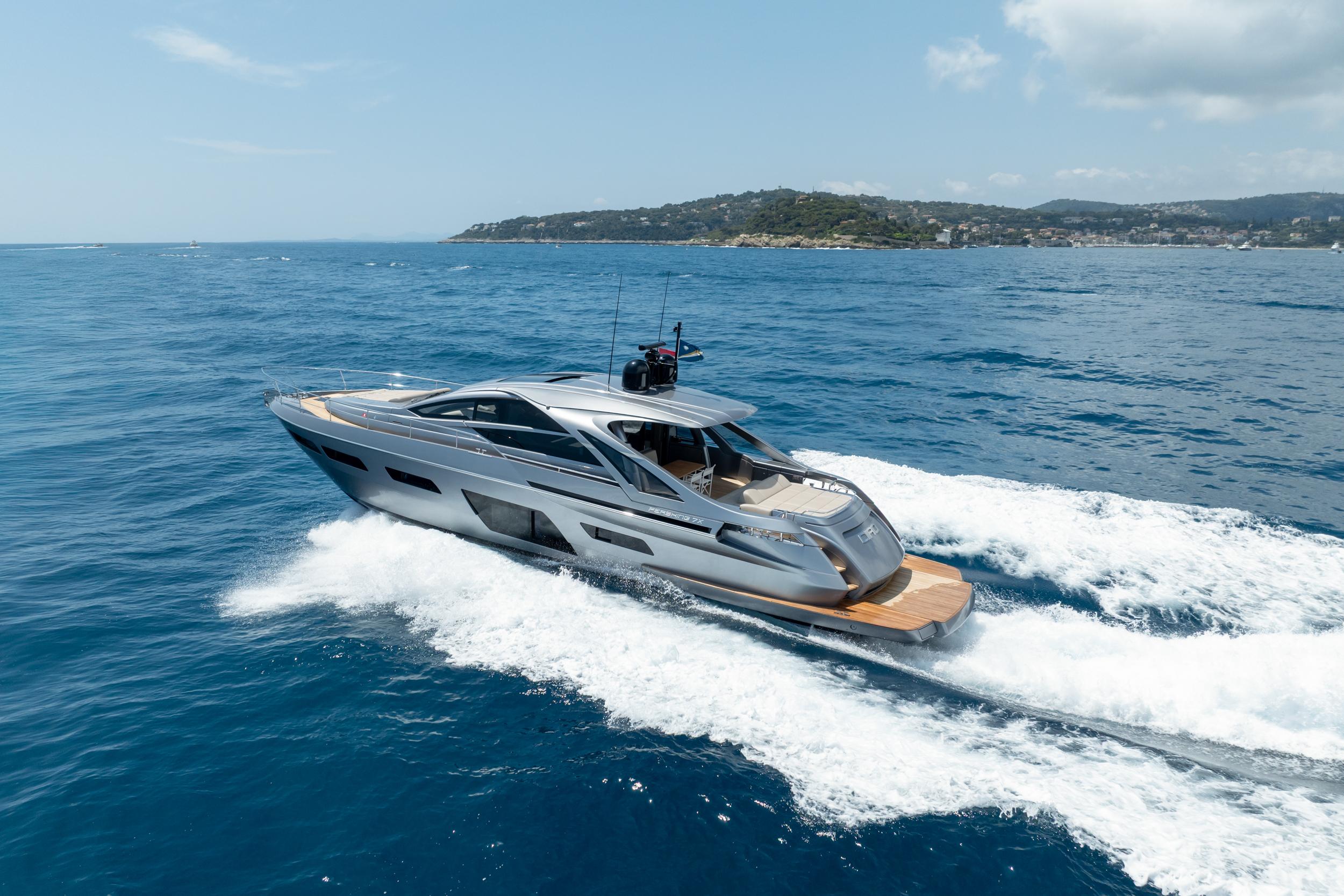 2024 Pershing 7X yacht cruising on open sea with scenic coastline in background.