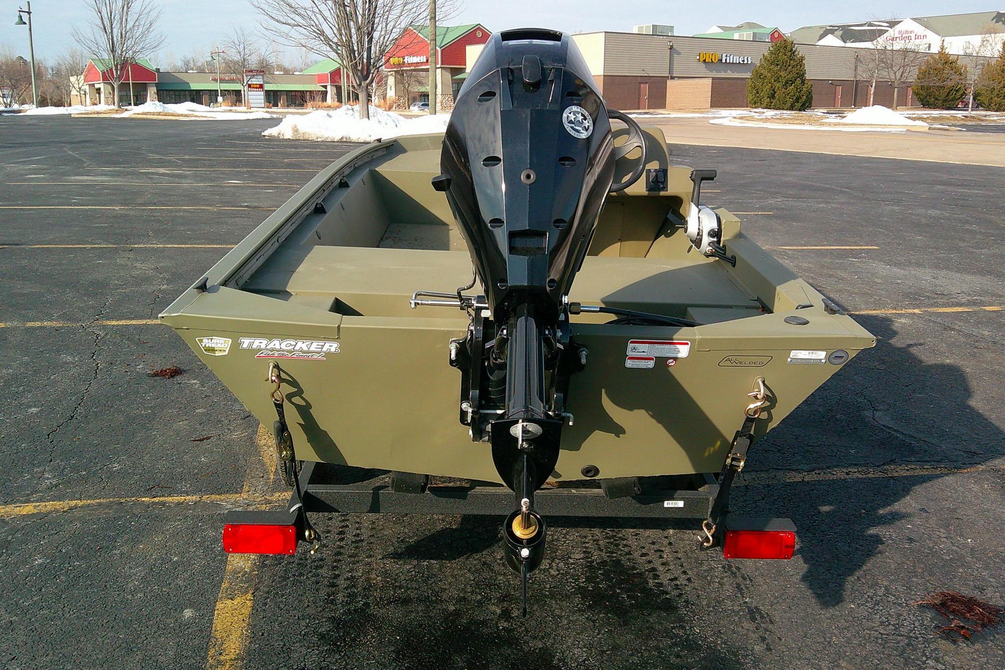 2025 Tracker Grizzly 1648 SC boat with motor in parking lot.