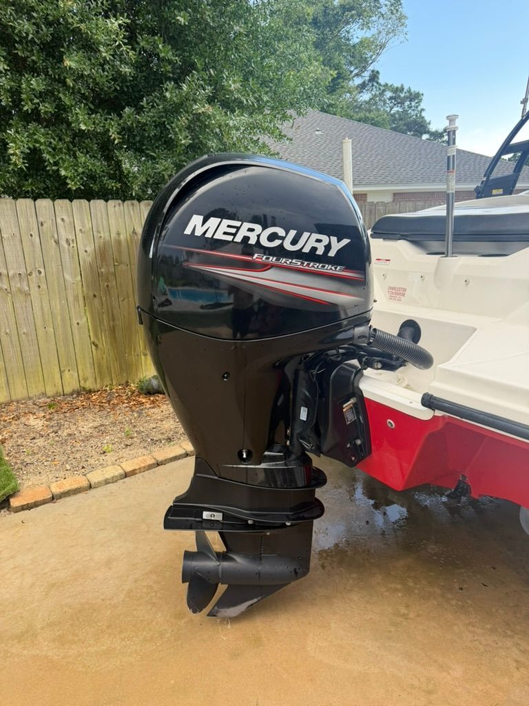A Mercury FourStroke outboard motor on a Sea Ray boat in a driveway.