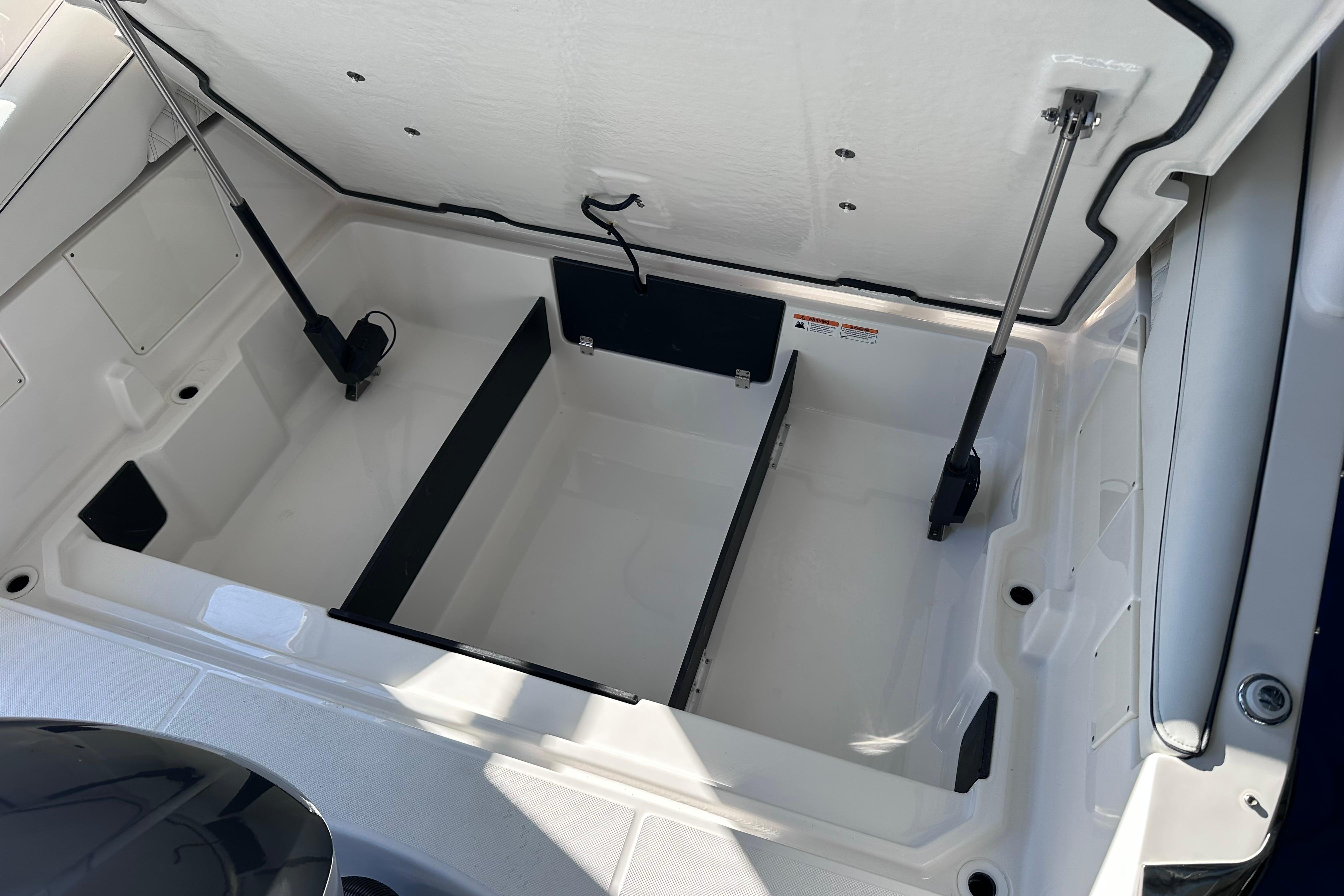 Open storage compartment in 2026 Regal LX4 boat, showcasing spacious interior design.