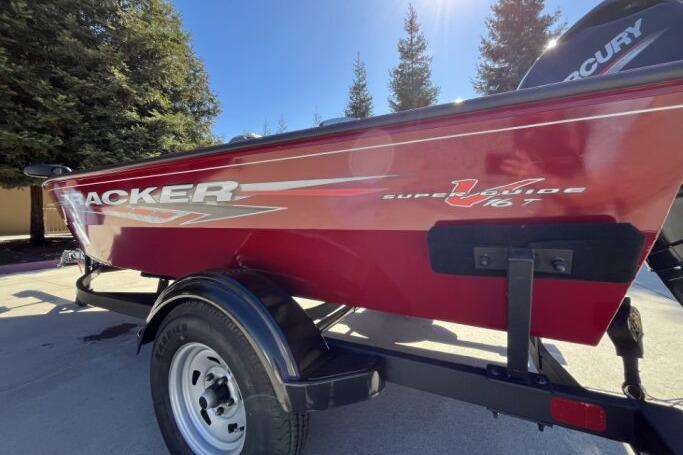 2025 Tracker Super Guide V-16 T boat in vibrant red on a trailer.