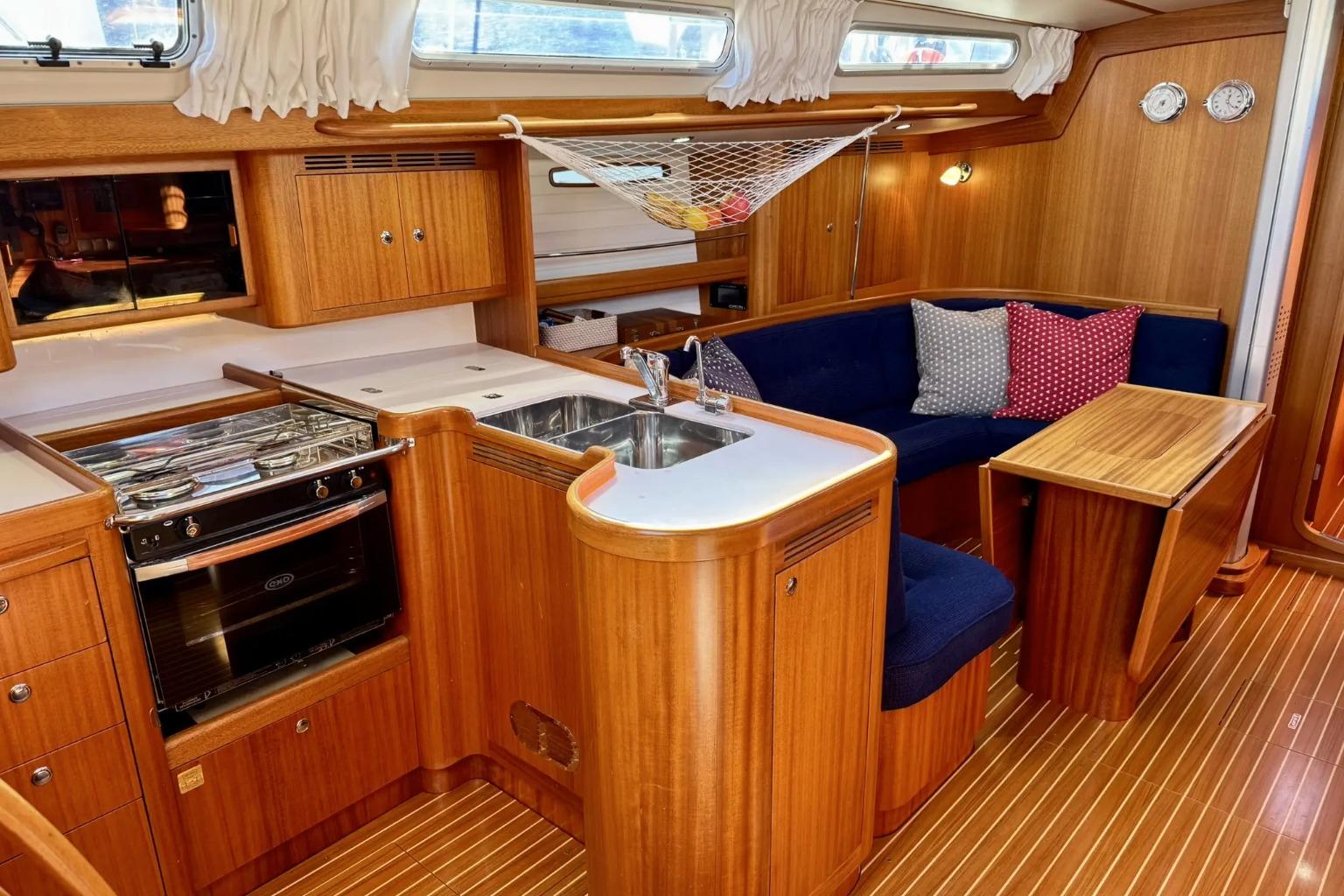 Luxurious interior of 2010 Arcona 430 yacht with wooden cabinetry and cozy seating area.