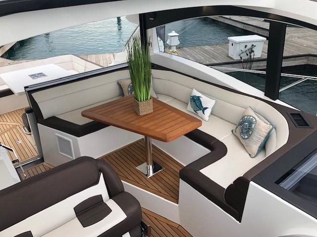 Luxurious seating area on 2018 Galeon 485 yacht with elegant cushions and wooden table.