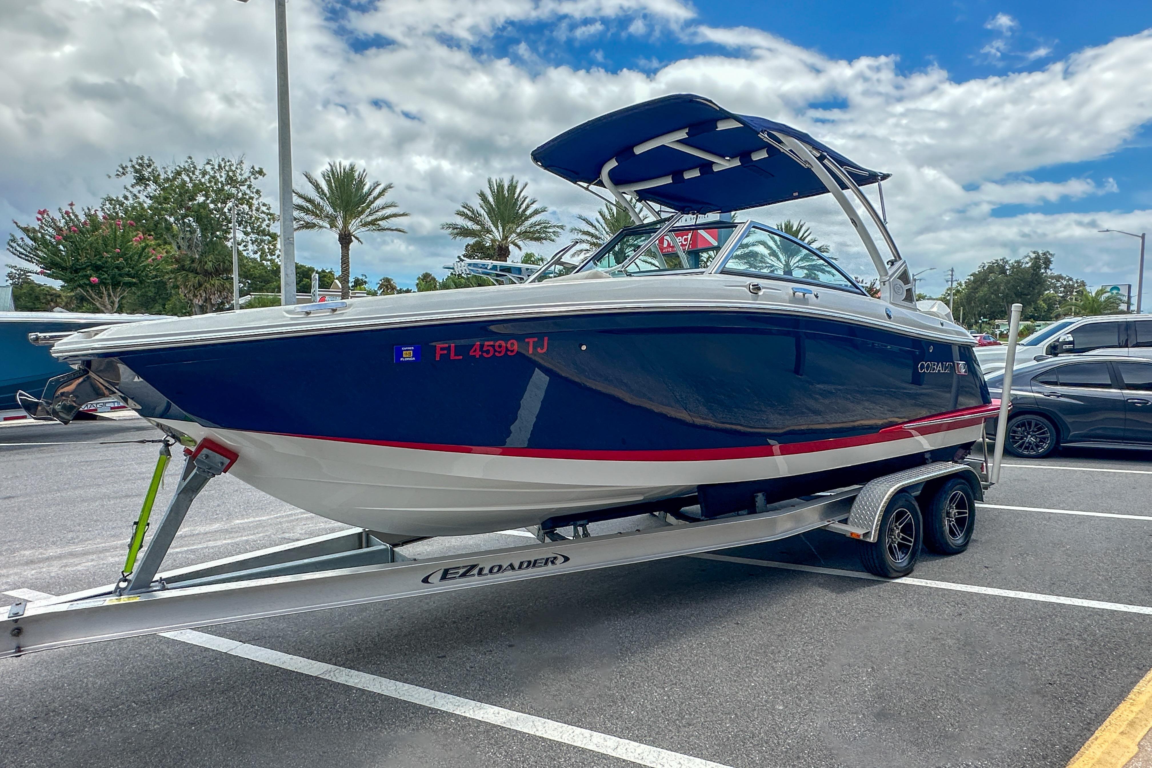 2022 Cobalt 25SC boat on trailer in parking lot, blue and white design.