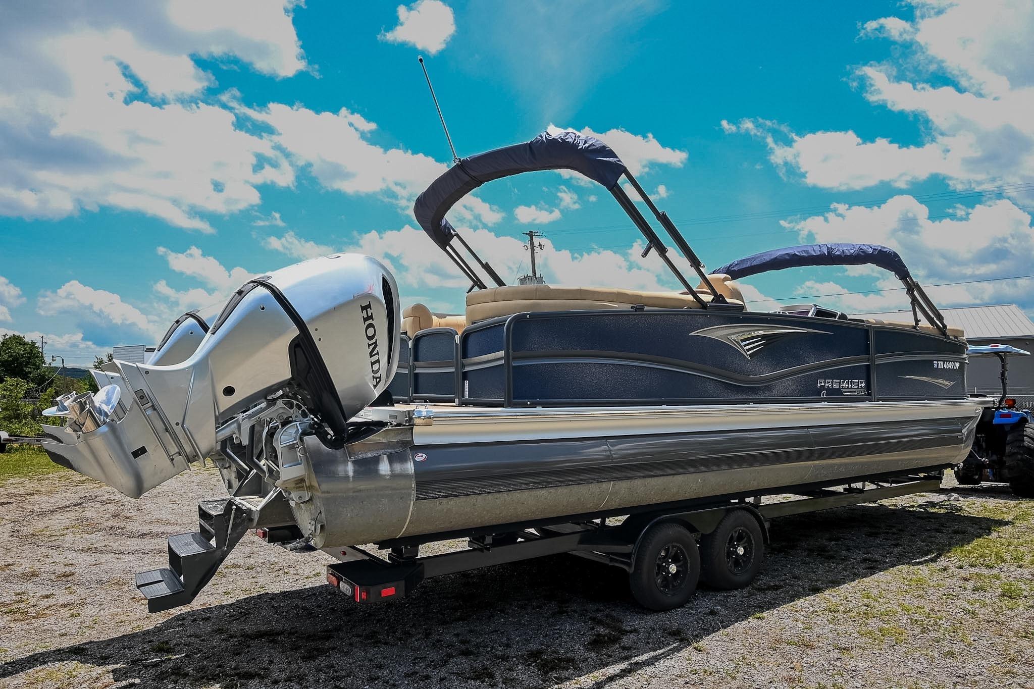 2023 Premier 270 Intrigue RF pontoon boat with Honda outboard motor on trailer.