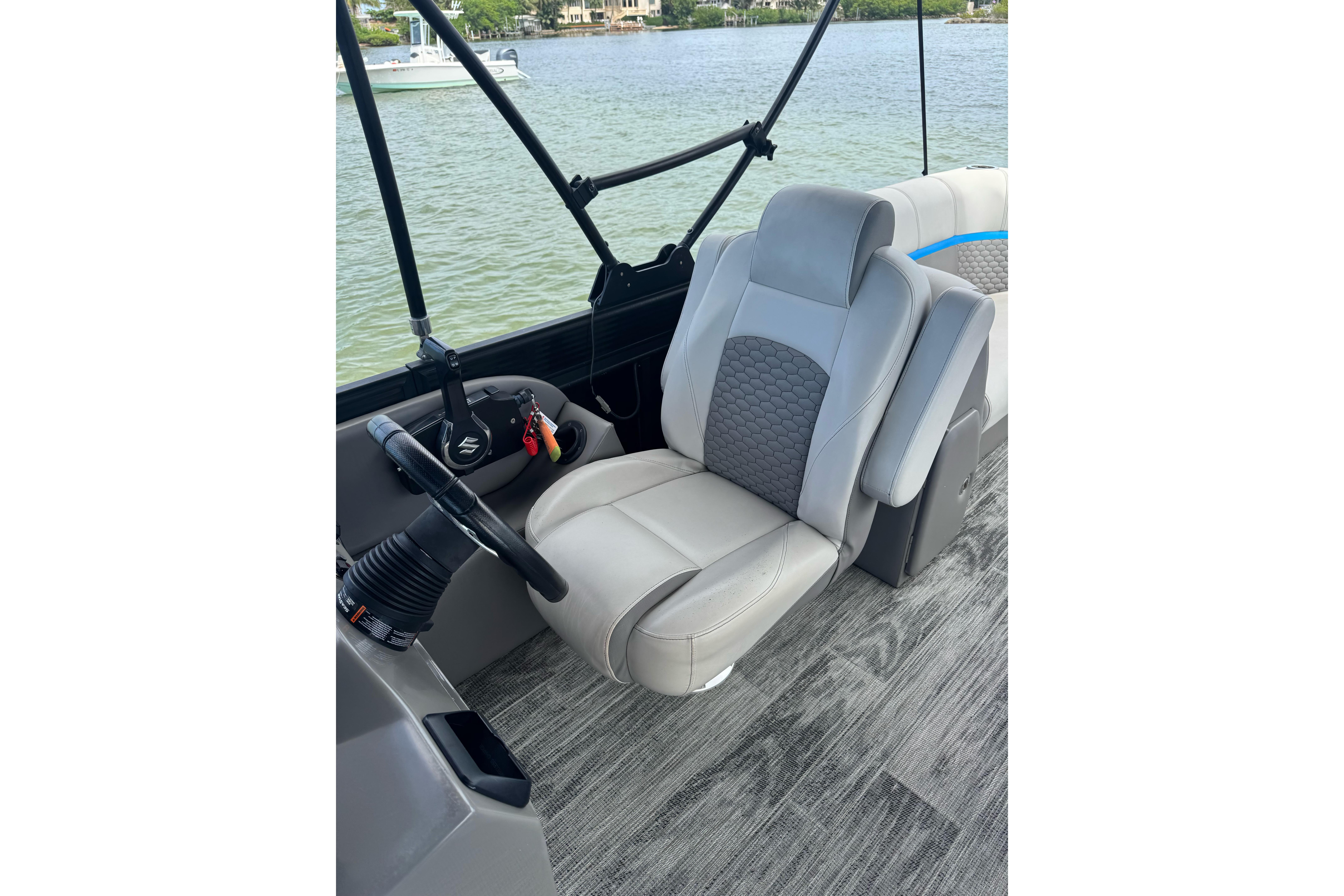 Captain's seat on 2022 Qwest Edge 820 CTR boat, overlooking serene water.