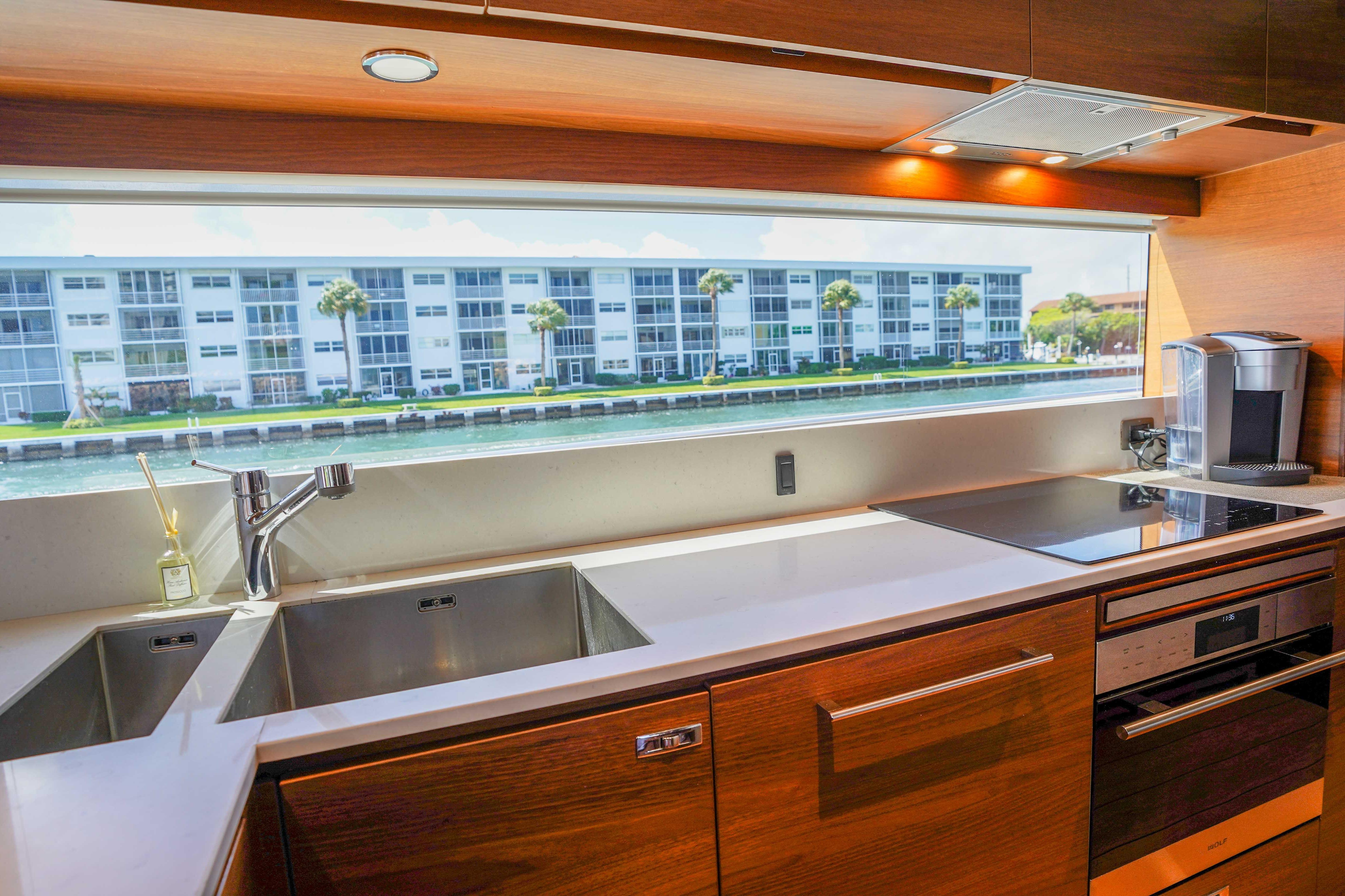 Luxurious kitchen interior of 2021 Princess Y85 yacht with modern appliances and waterfront view.