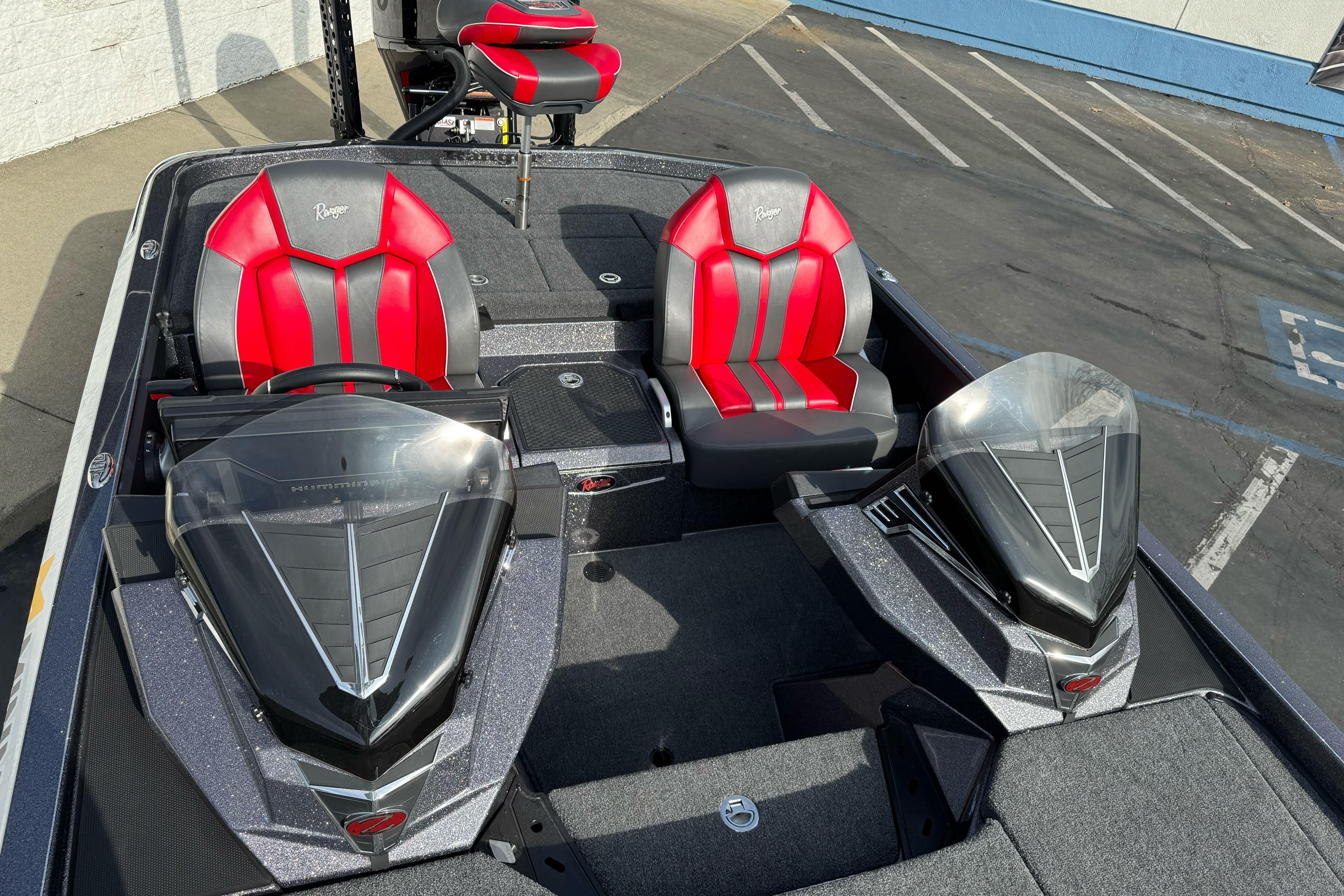 2025 Ranger Z521 boat interior with red and black seats, parked in a lot.