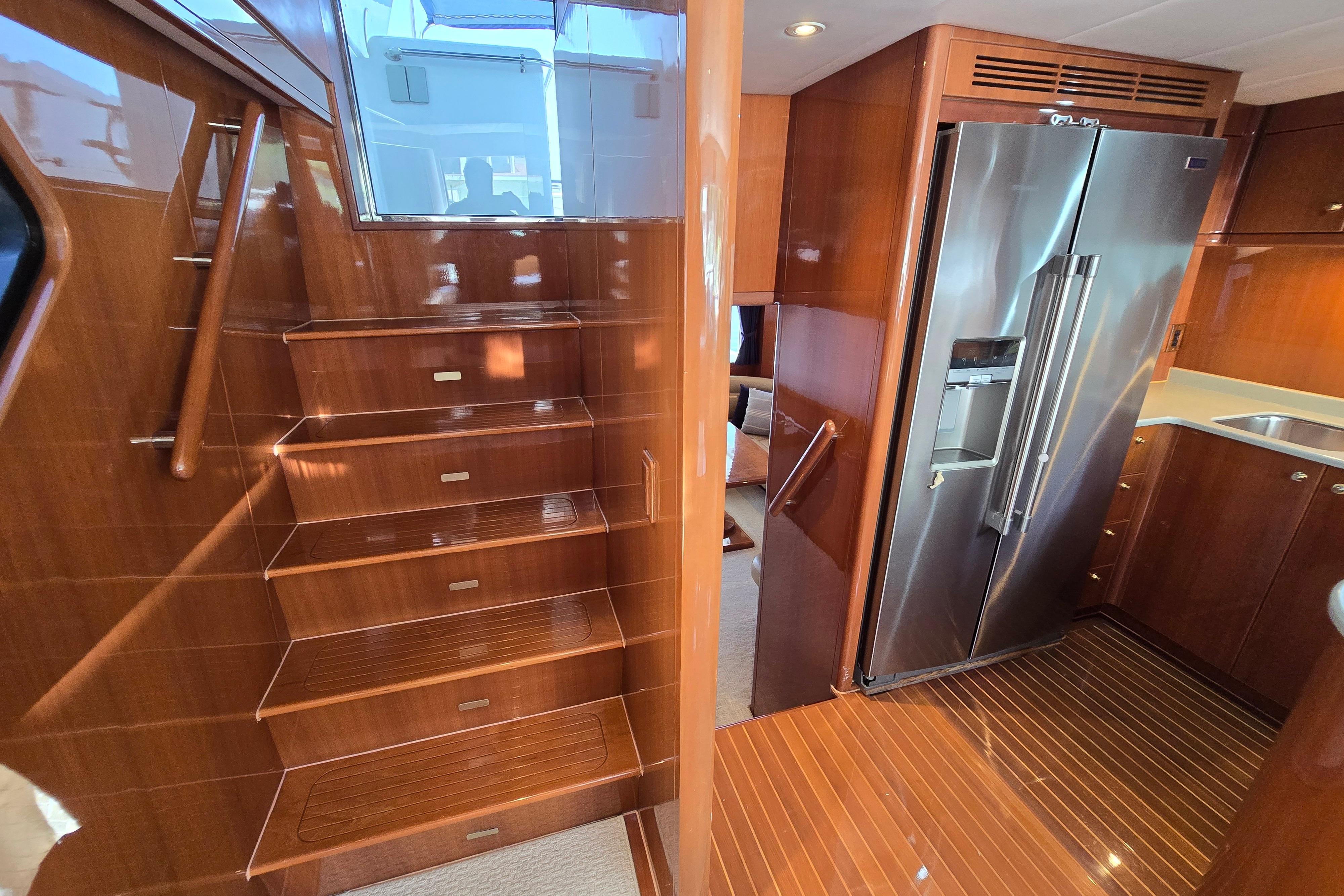 Luxurious 2004 Grand Harbour 58 yacht interior with wooden stairs and modern kitchen.