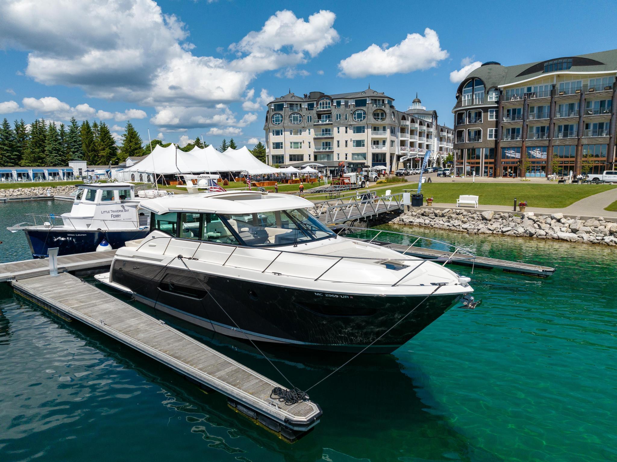 2022 Tiara Yachts C49 Coupe docked in a scenic marina with buildings in the background.