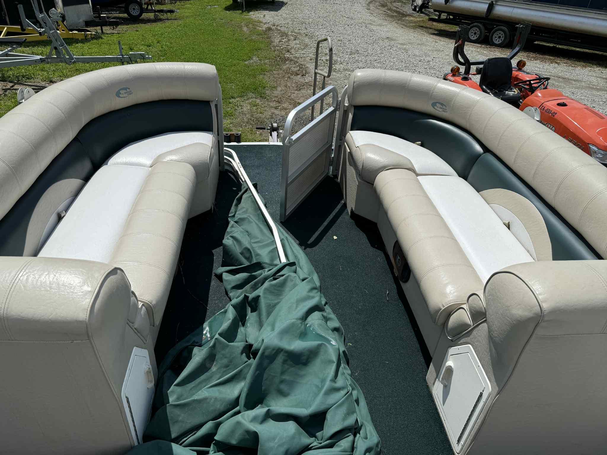 1999 Smoker Craft 8526 Pleasure Isle I/O pontoon boat with spacious seating and green cover.