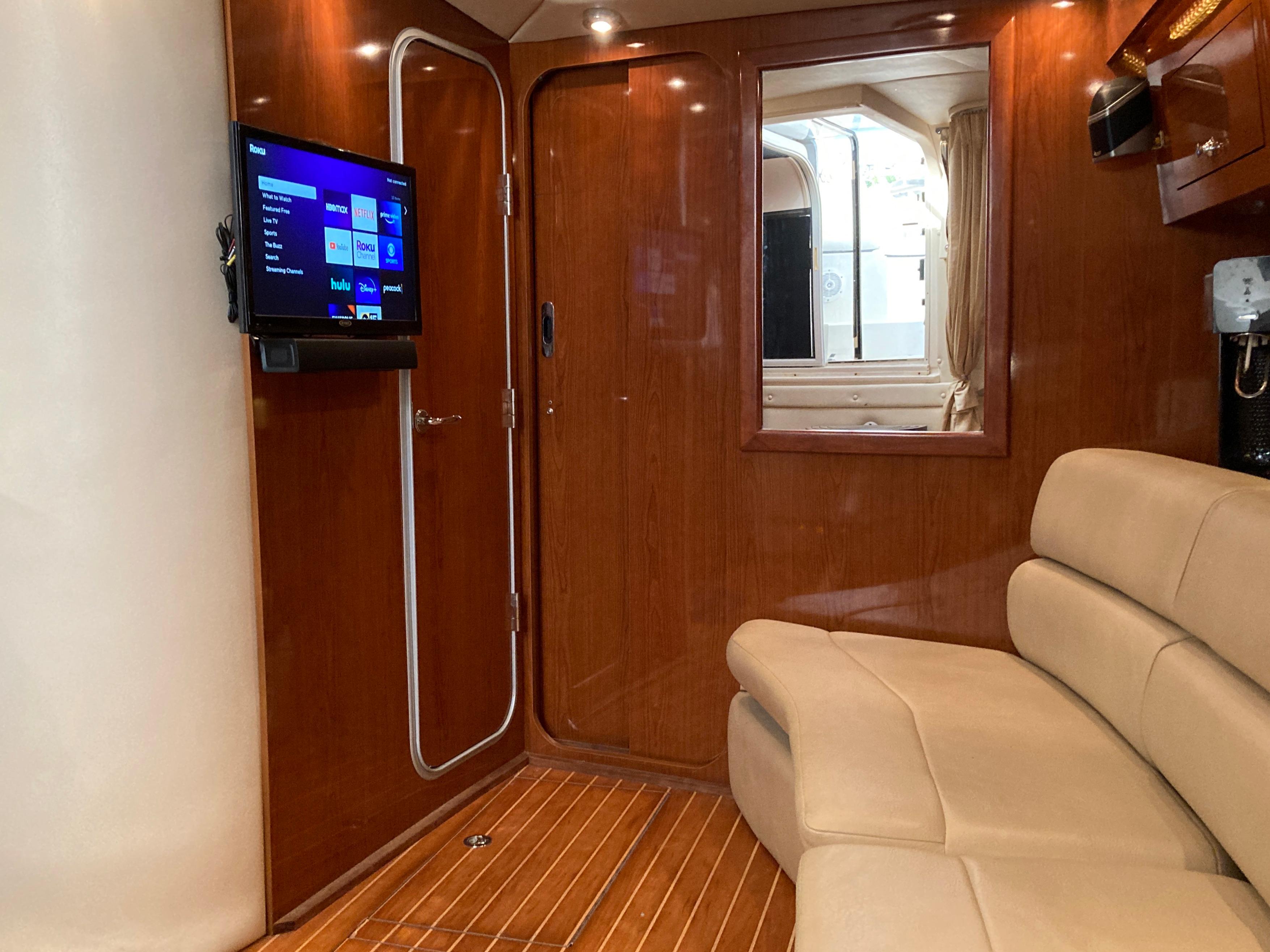 Interior of 2007 Regal 3760 Commodore yacht with TV and beige seating.