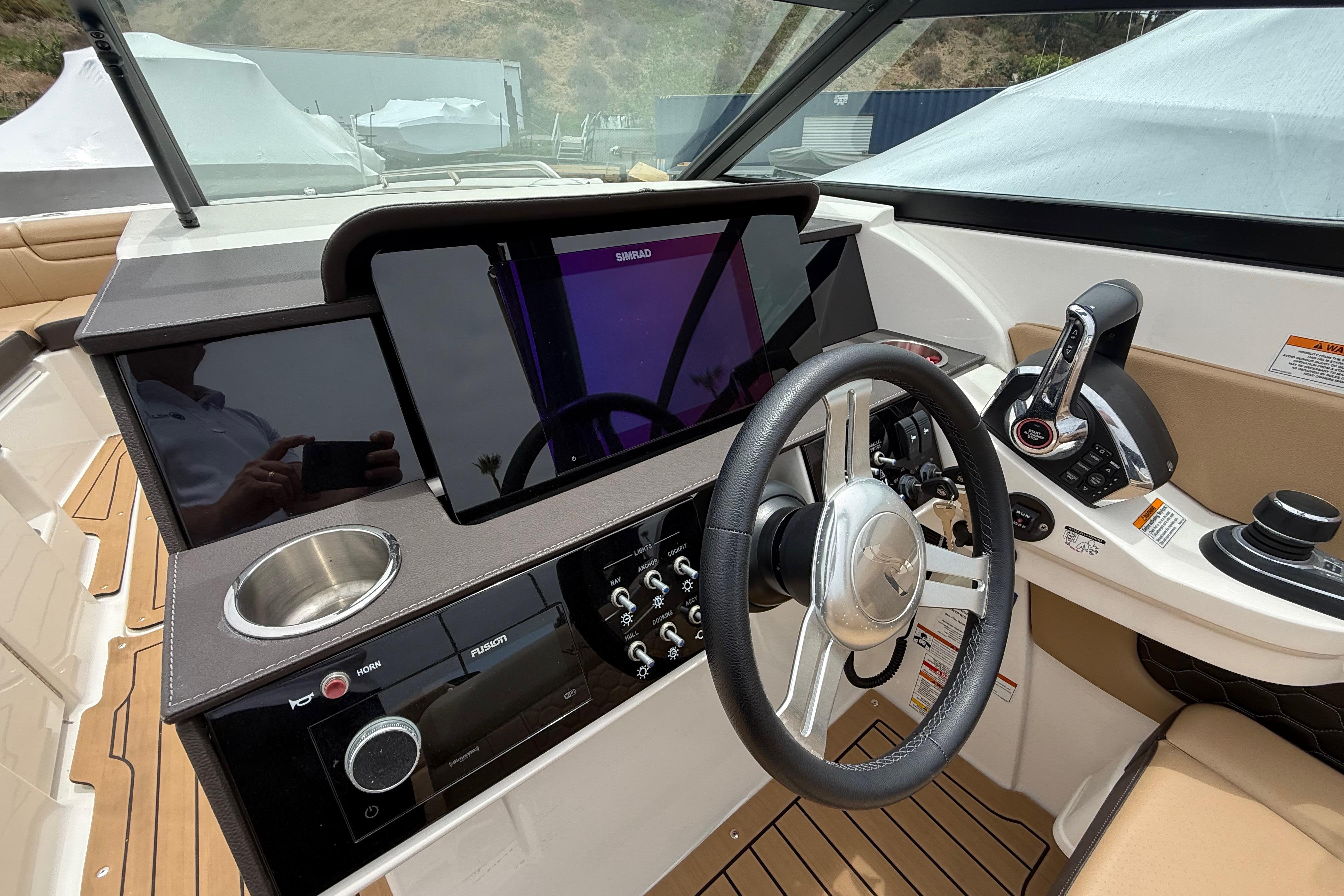2022 Sea Ray SDX 290 Outboard helm with steering wheel, controls, and navigation display.