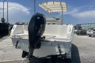 2023 Sailfish 242 CC boat with outboard motor, parked outdoors under clear sky.