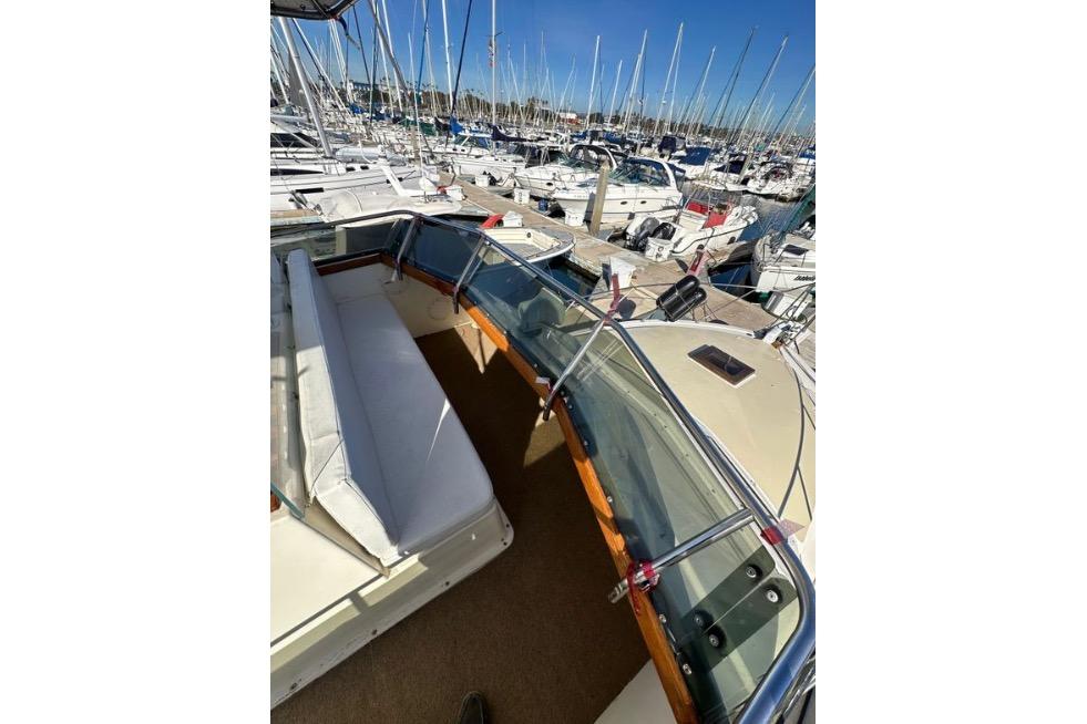 1985 Egg Harbor 33 Sedan boat interior with marina view, featuring seating and windshield.