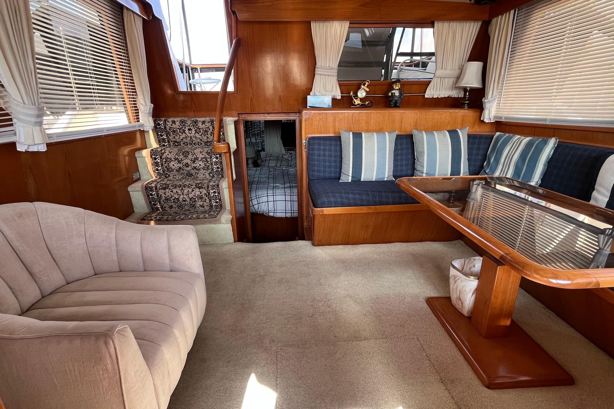 Interior of 1989 Ocean Alexander 440 Sundeck CPMY with plush seating and wooden accents.