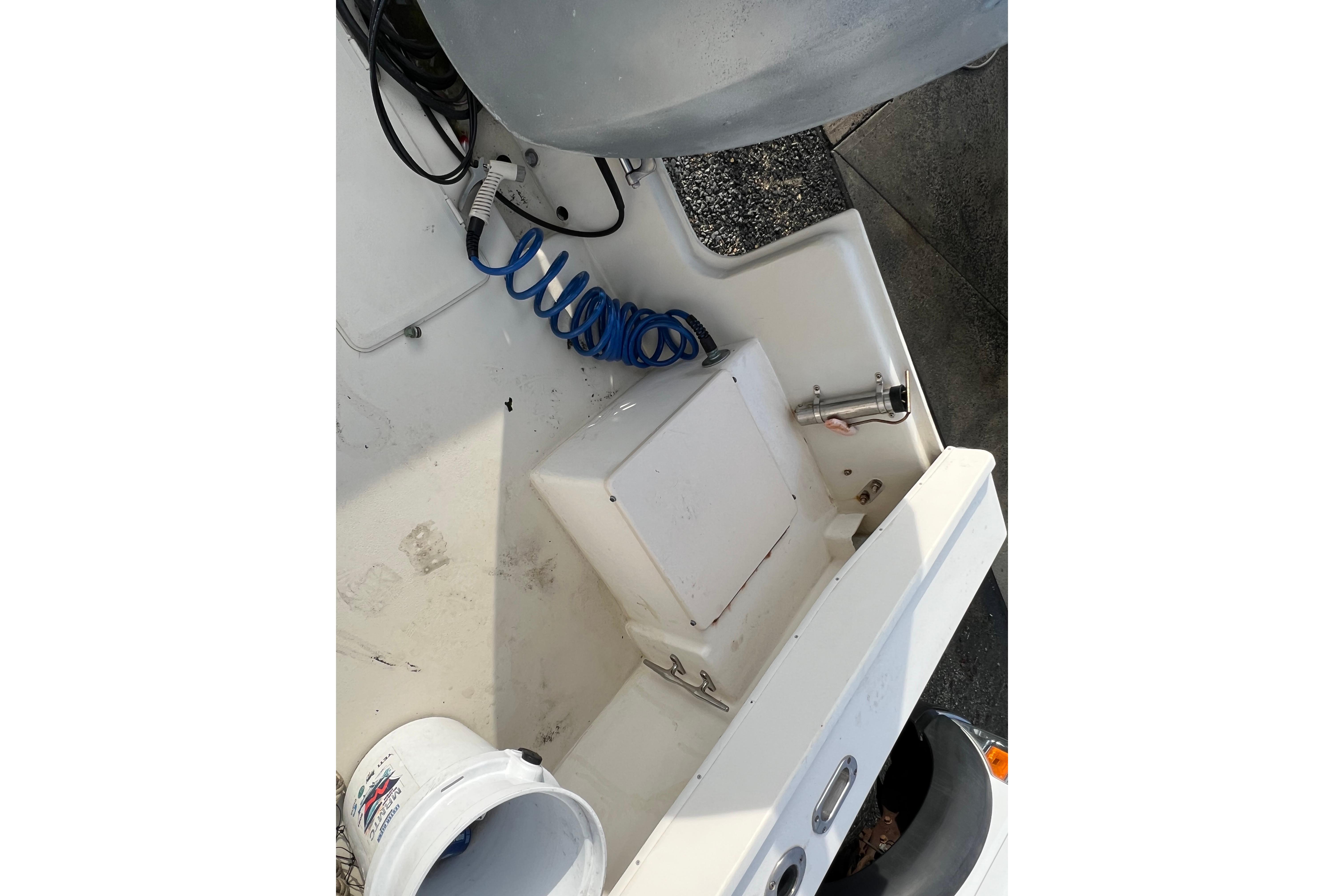 2001 Parker 2520 Deep Vee Sport Cabin boat deck with coiled hose and bucket.