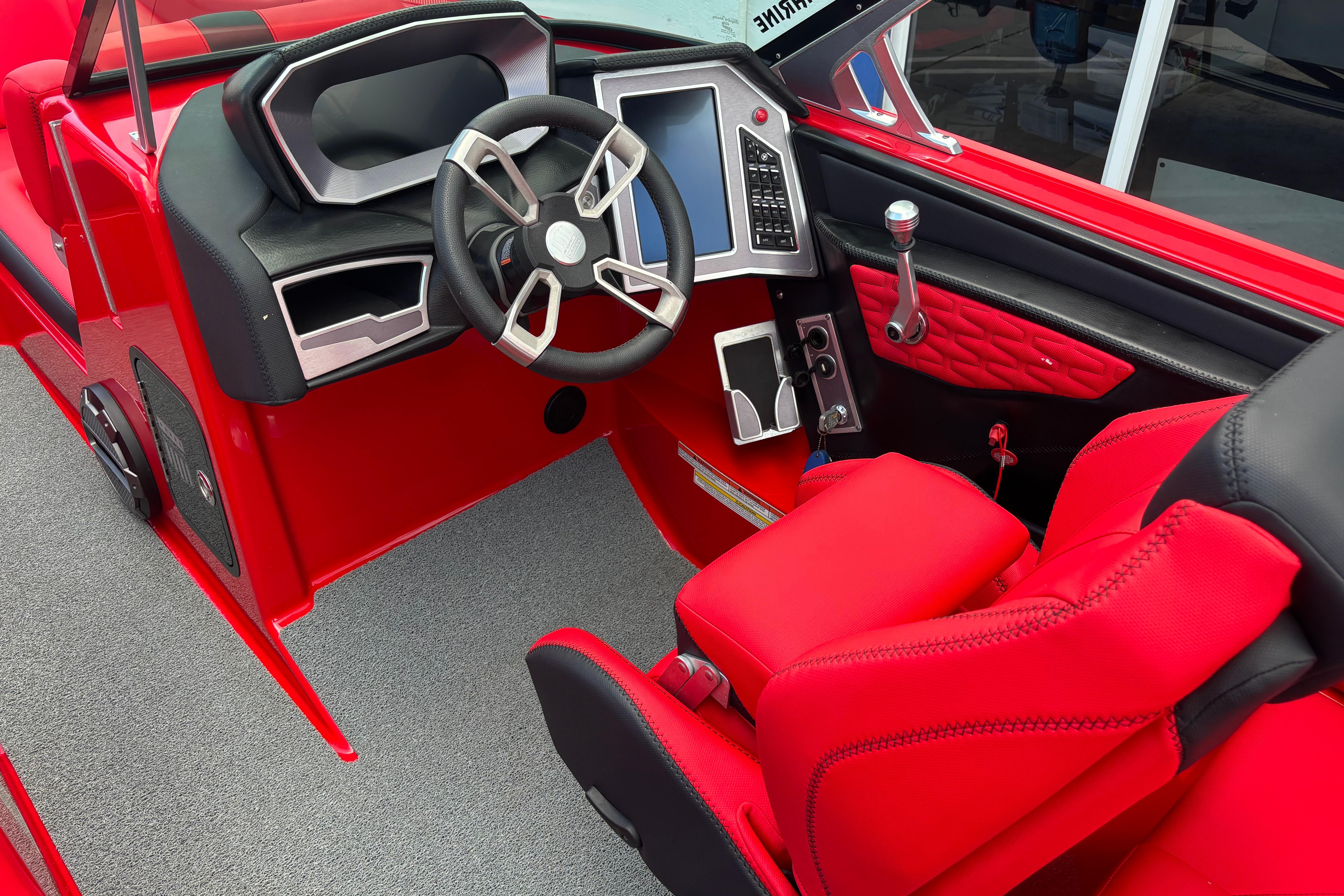 Red 2020 MasterCraft X24 boat interior with modern steering and control panel.