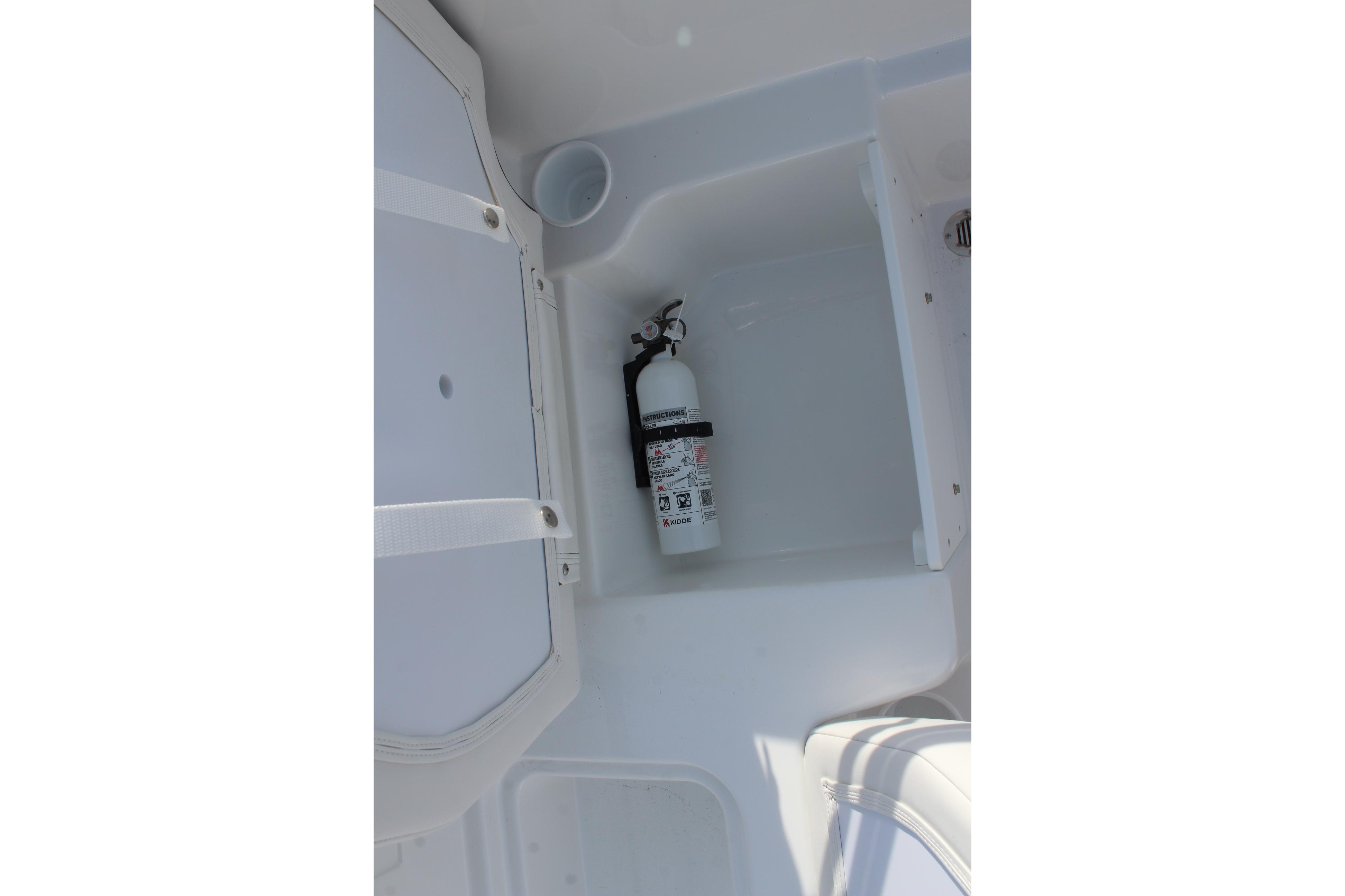 Fire extinguisher in 2026 Tahoe T18 boat compartment, white interior.