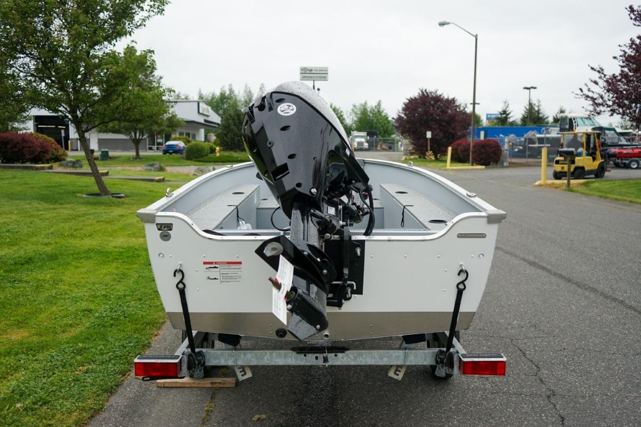 2026 Lund 1400 Fury Tiller boat on trailer, parked outdoors.