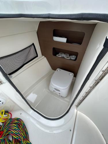 2013 Sea Ray 240 Sundeck interior with compact toilet and storage shelves.
