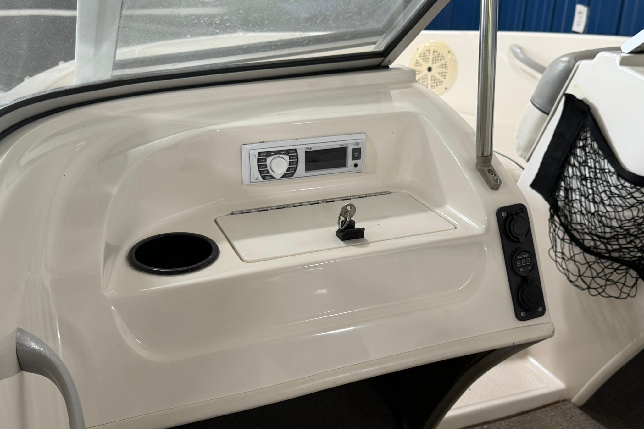 2012 Bayliner 175 Bowrider dashboard with stereo, cup holder, and storage compartment.
