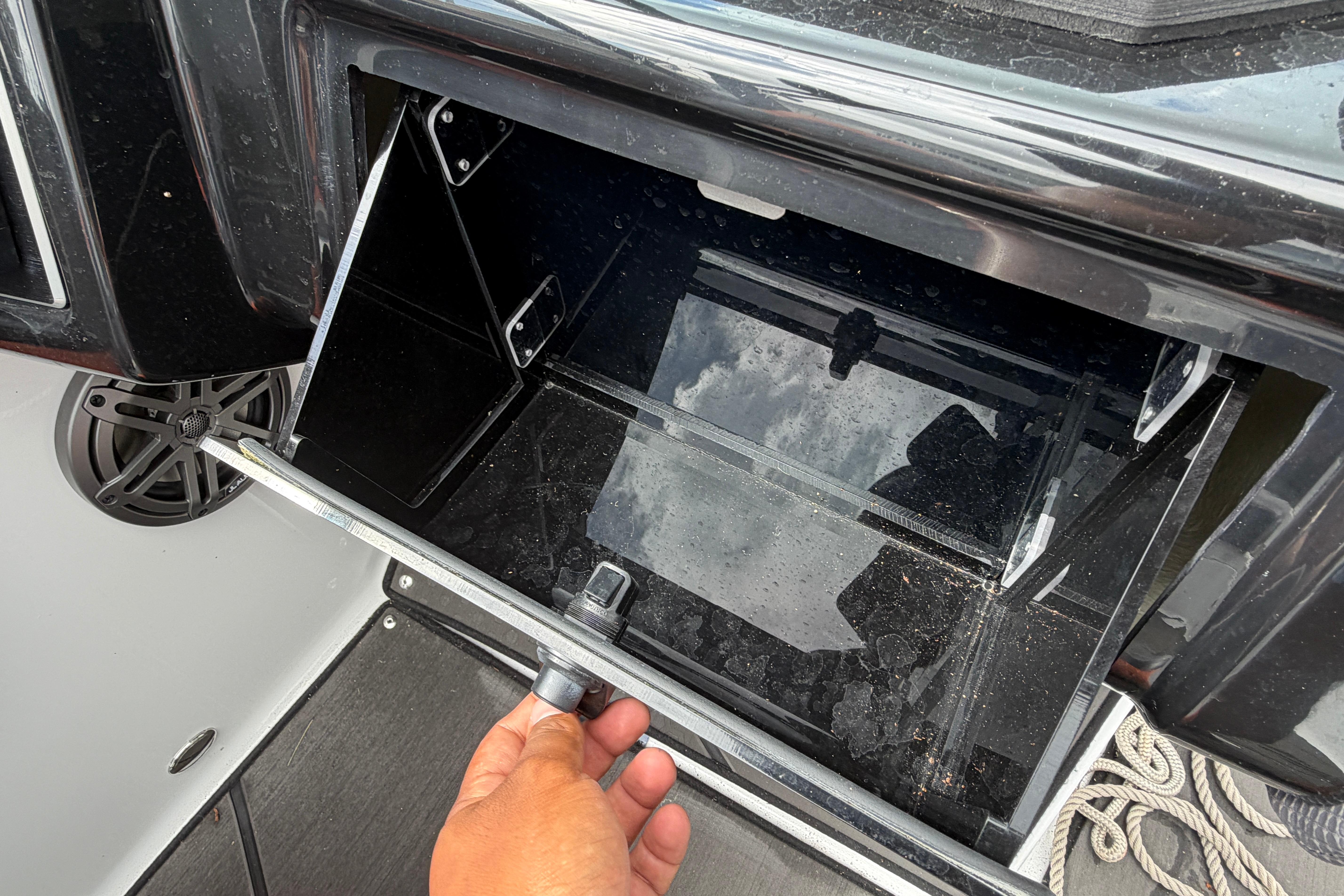 Open storage compartment in 2026 Scarab 235 LX boat, showing interior details.