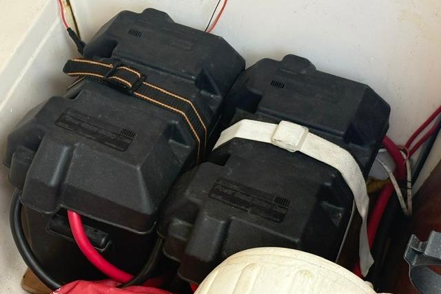 Battery compartment of a 2000 Beneteau Oceanis 321 sailboat with secured cables.