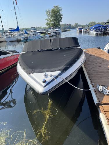 2005 Crownline 180 BR boat docked in a marina, covered and secured.