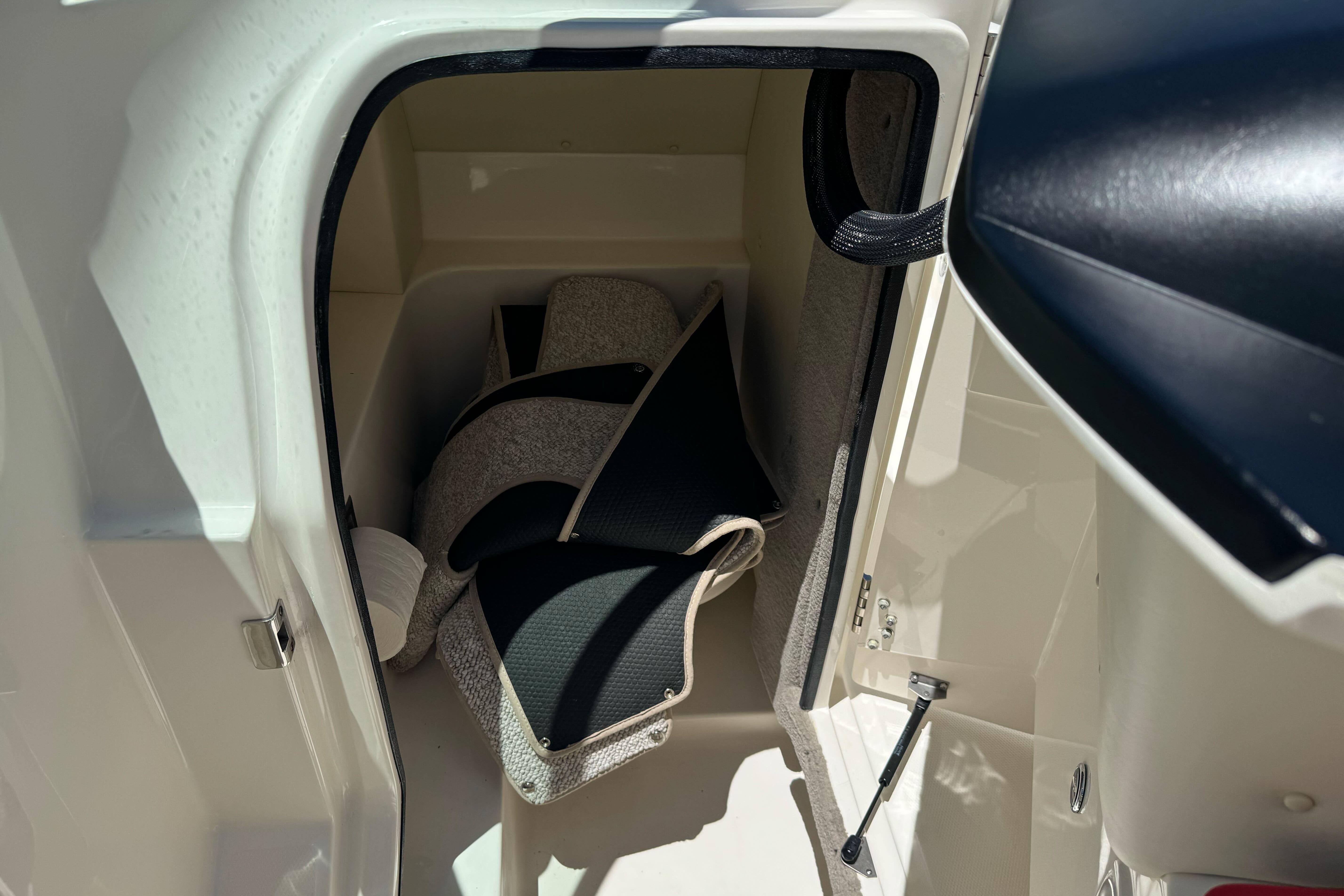 Storage compartment in a 2007 Sea Ray SLX 250 boat, featuring cushions and accessories.
