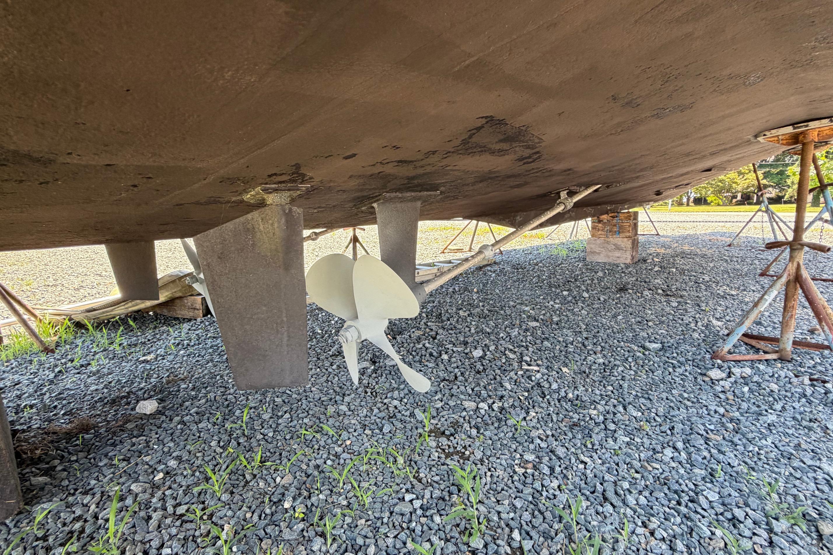 Underneath view of a 1995 Carver 356 Aft Cabin Motor Yacht on gravel.