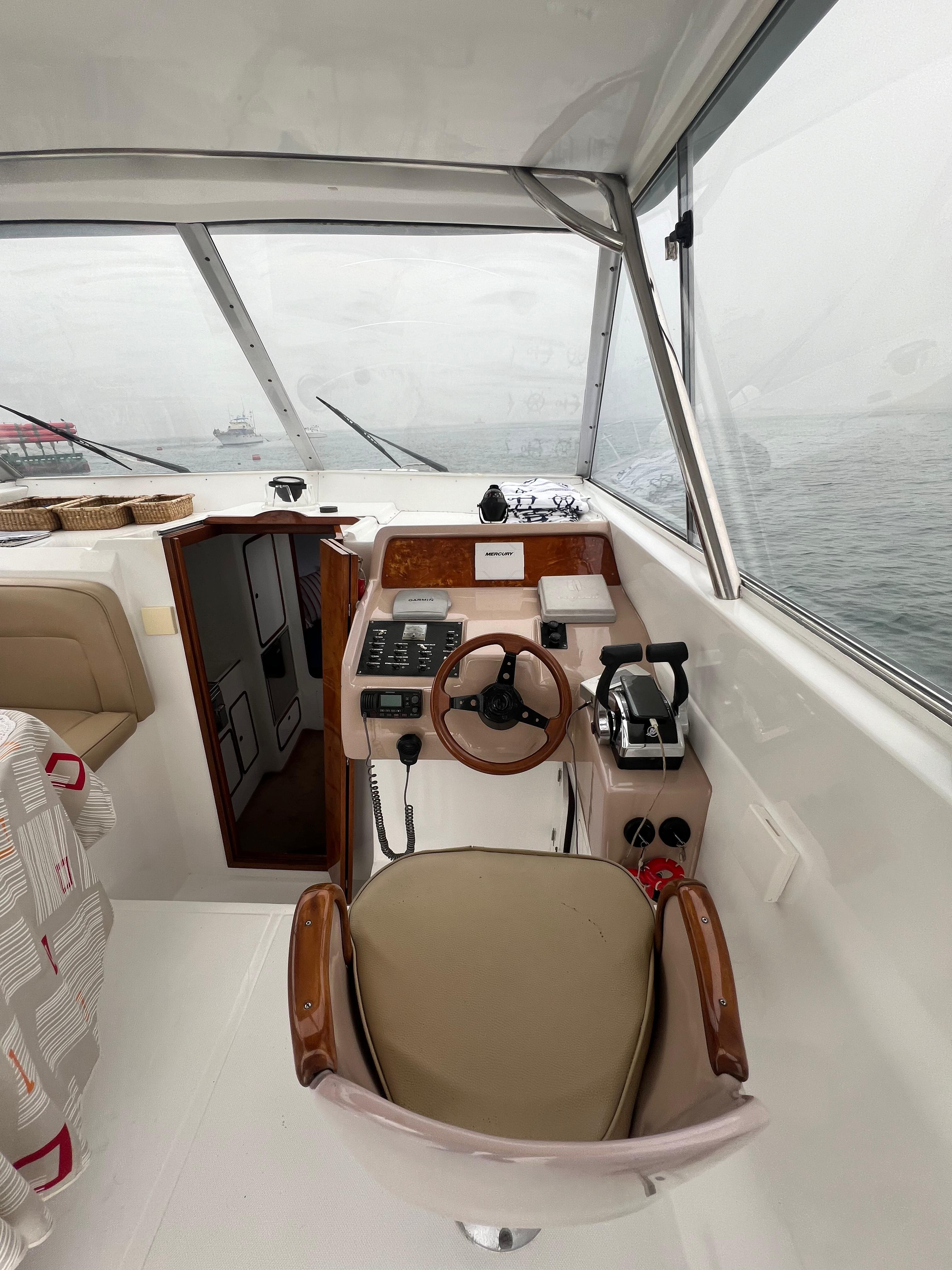 Interior view of a 1997 Custom 35 boat cockpit with steering wheel and controls.
