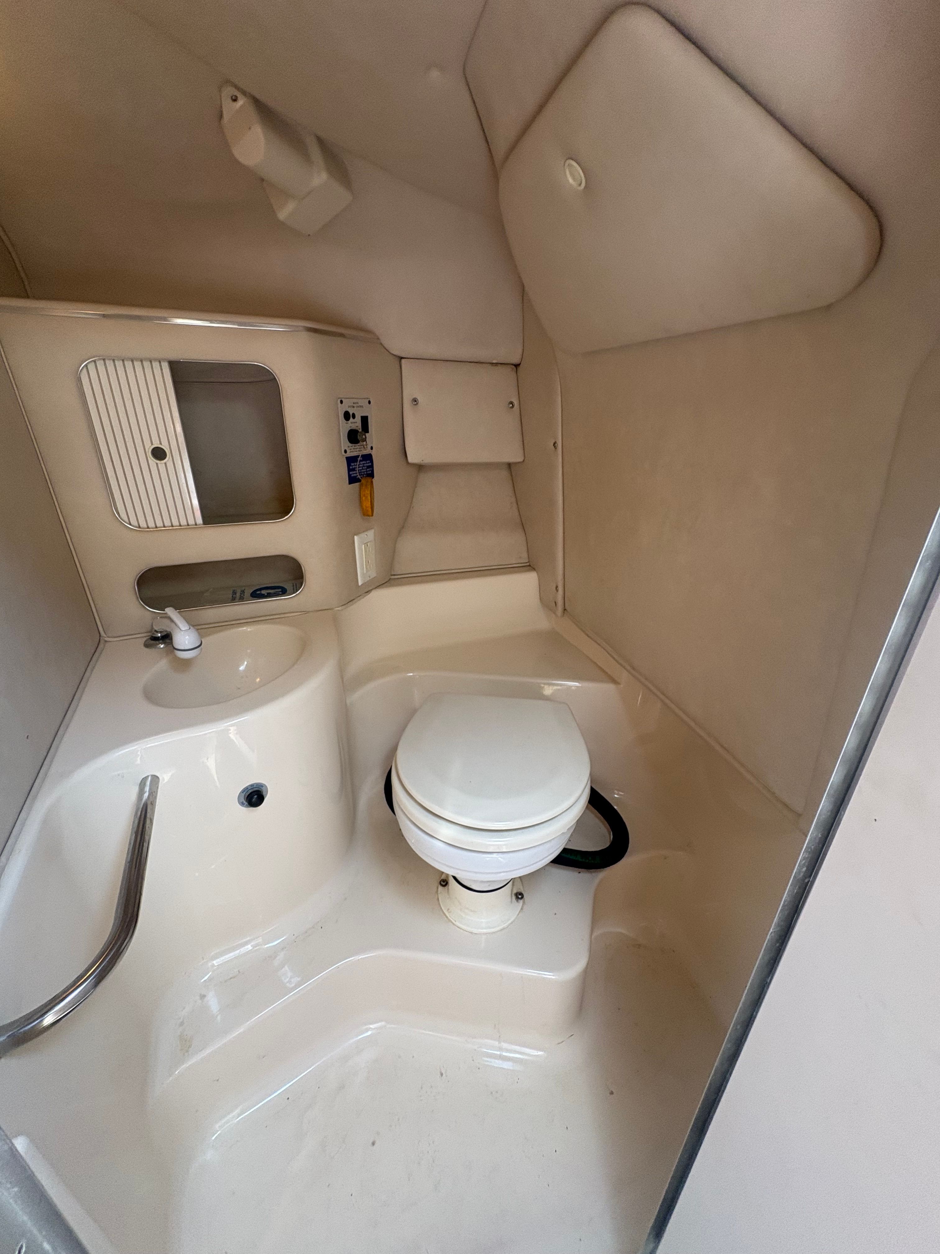 Interior of a 1996 Sea Ray 280 Cuddy Cabin featuring a toilet and sink.