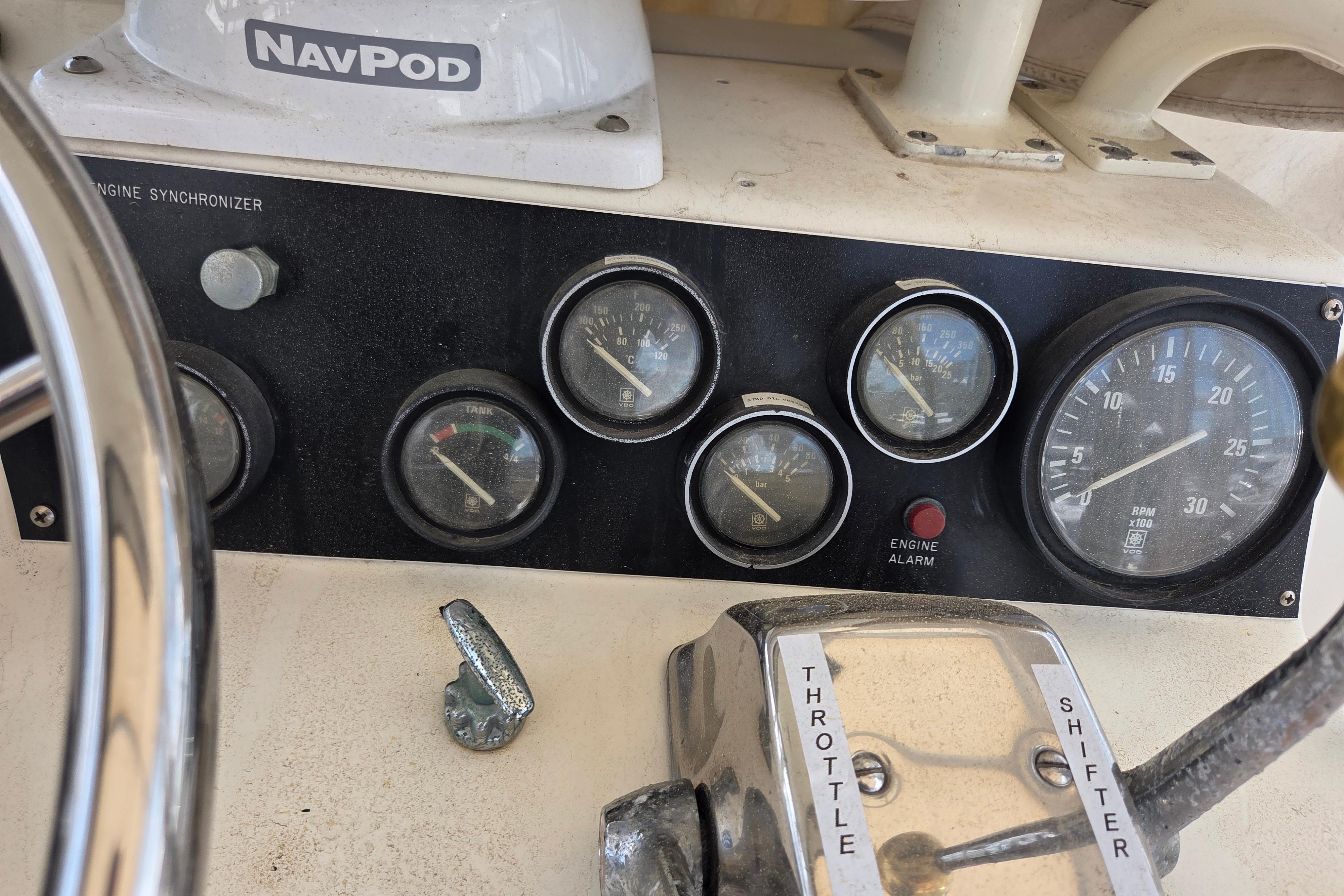 Control panel of a 1990 Egg Harbor Golden Egg 42 boat with gauges and throttle.