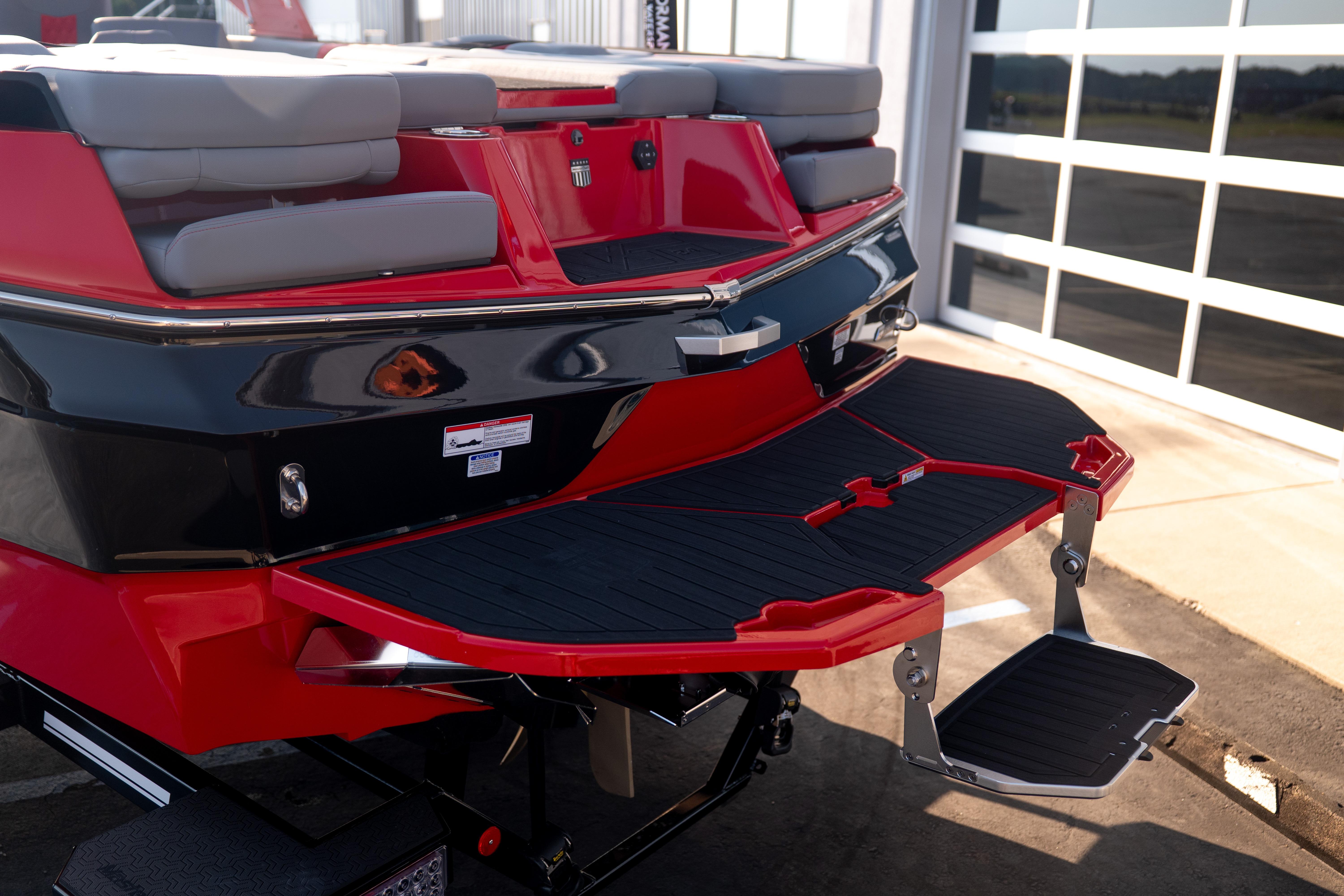 2027 MasterCraft XT24 boat rear view with red and black detailing, featuring a swim platform.