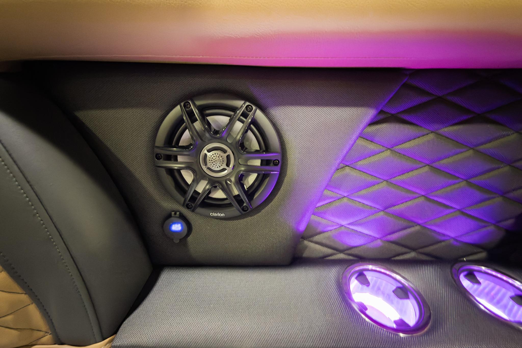 Luxurious interior of 2026 Godfrey Monaco 235 with speaker and ambient lighting.