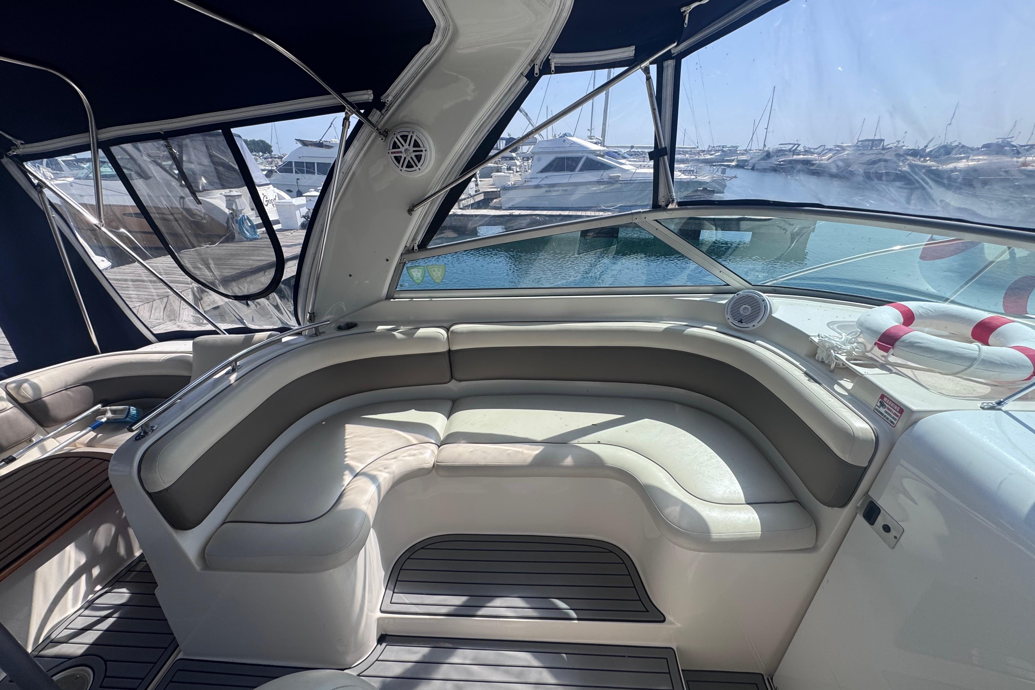 2003 Rinker Fiesta Vee 312 boat interior with cushioned seating and marina view.