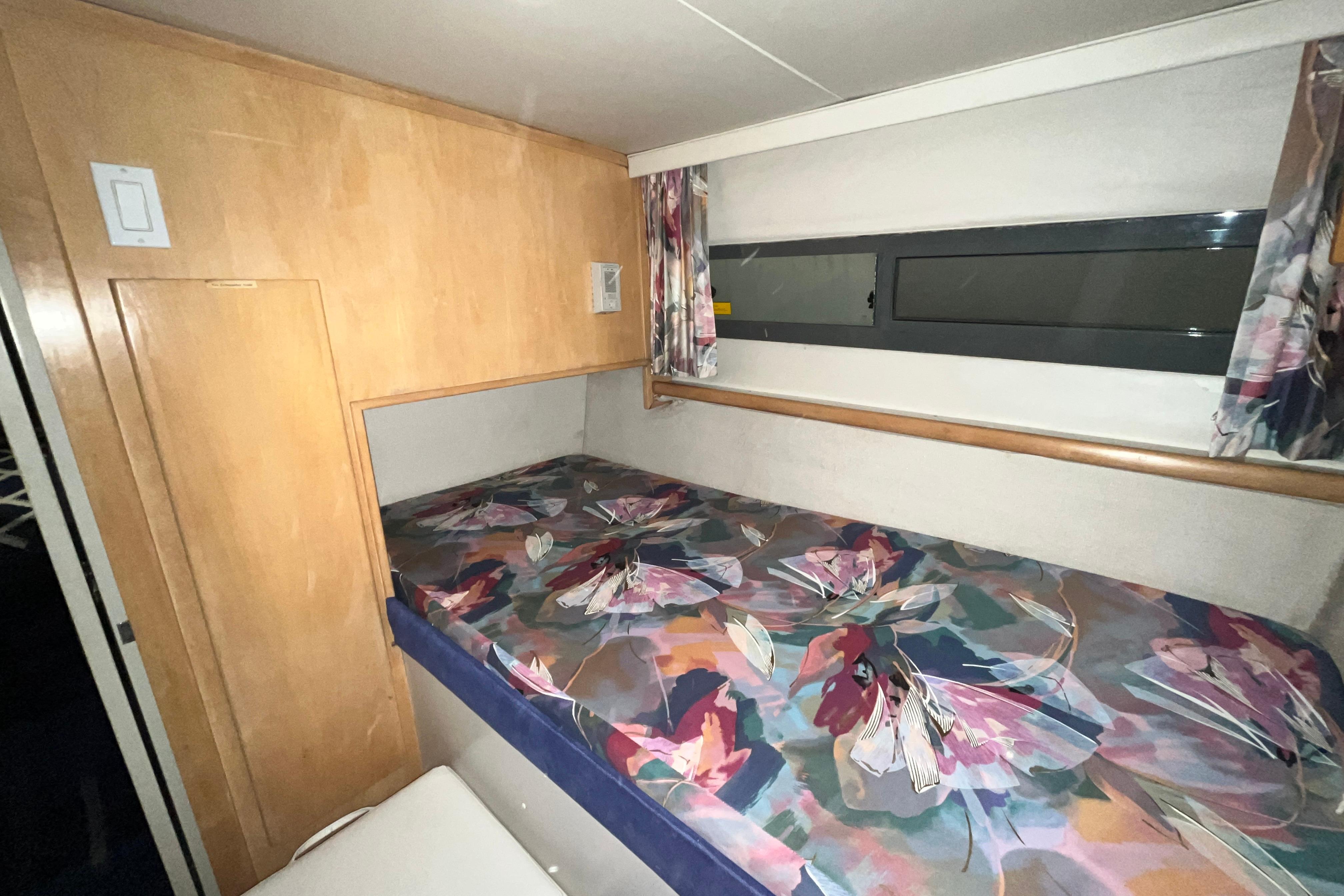 Cozy cabin interior of 1995 Carver 325 Aft Cabin Motor Yacht with floral bedding.