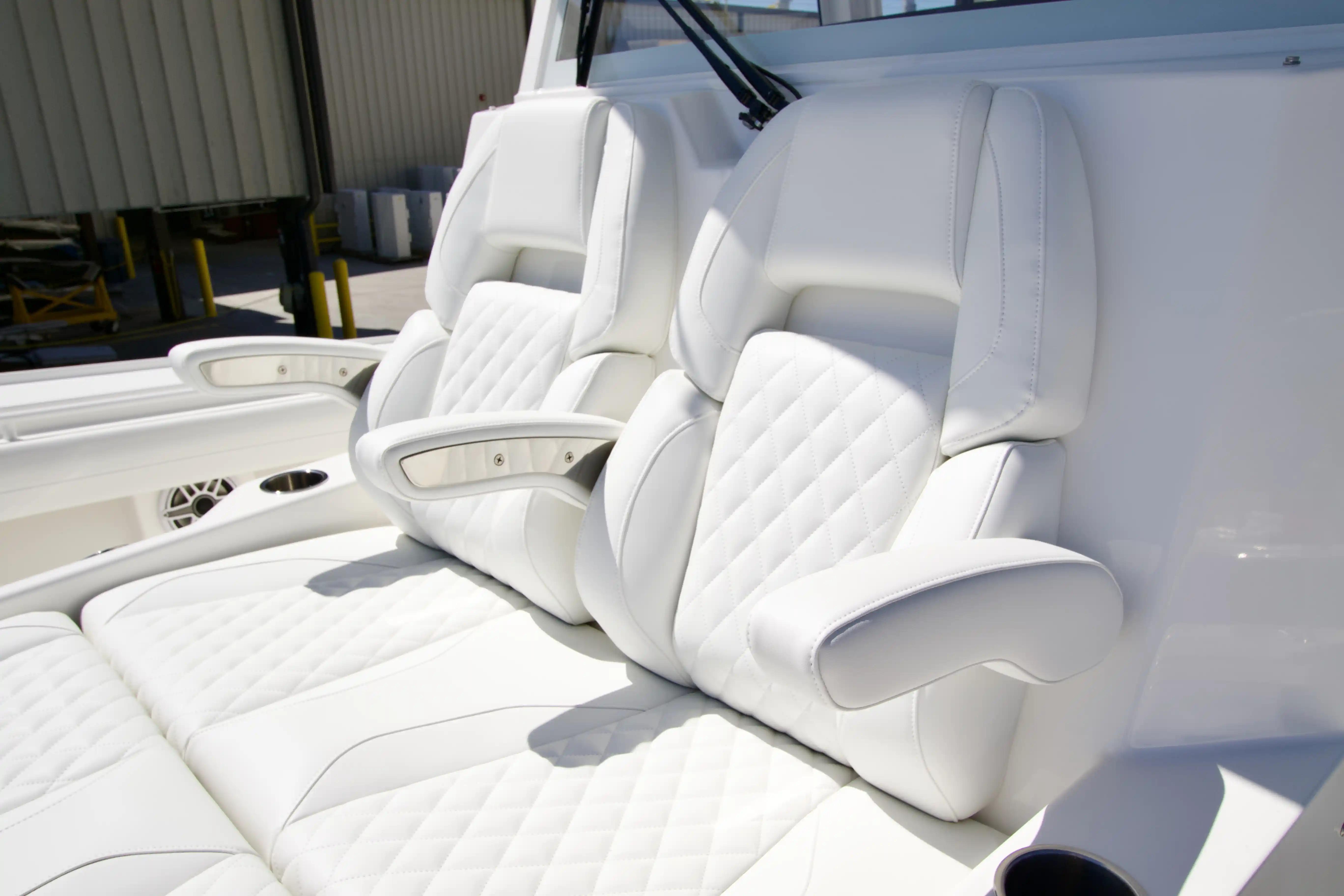 Luxurious white seating on 2027 Regulator 35 boat, featuring quilted design and armrests.