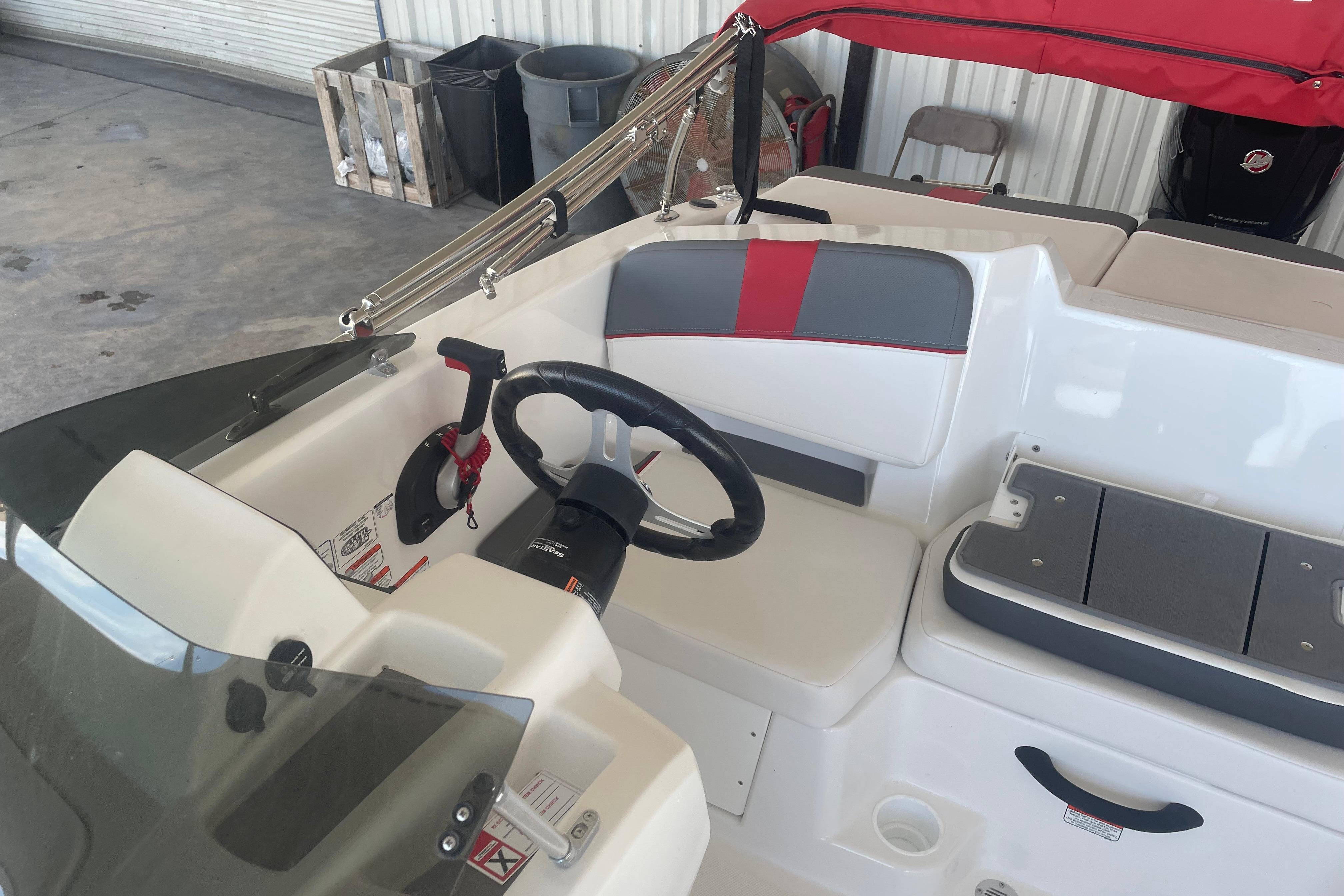 2026 Tahoe T18 boat interior with steering wheel and seating, featuring red and gray accents.