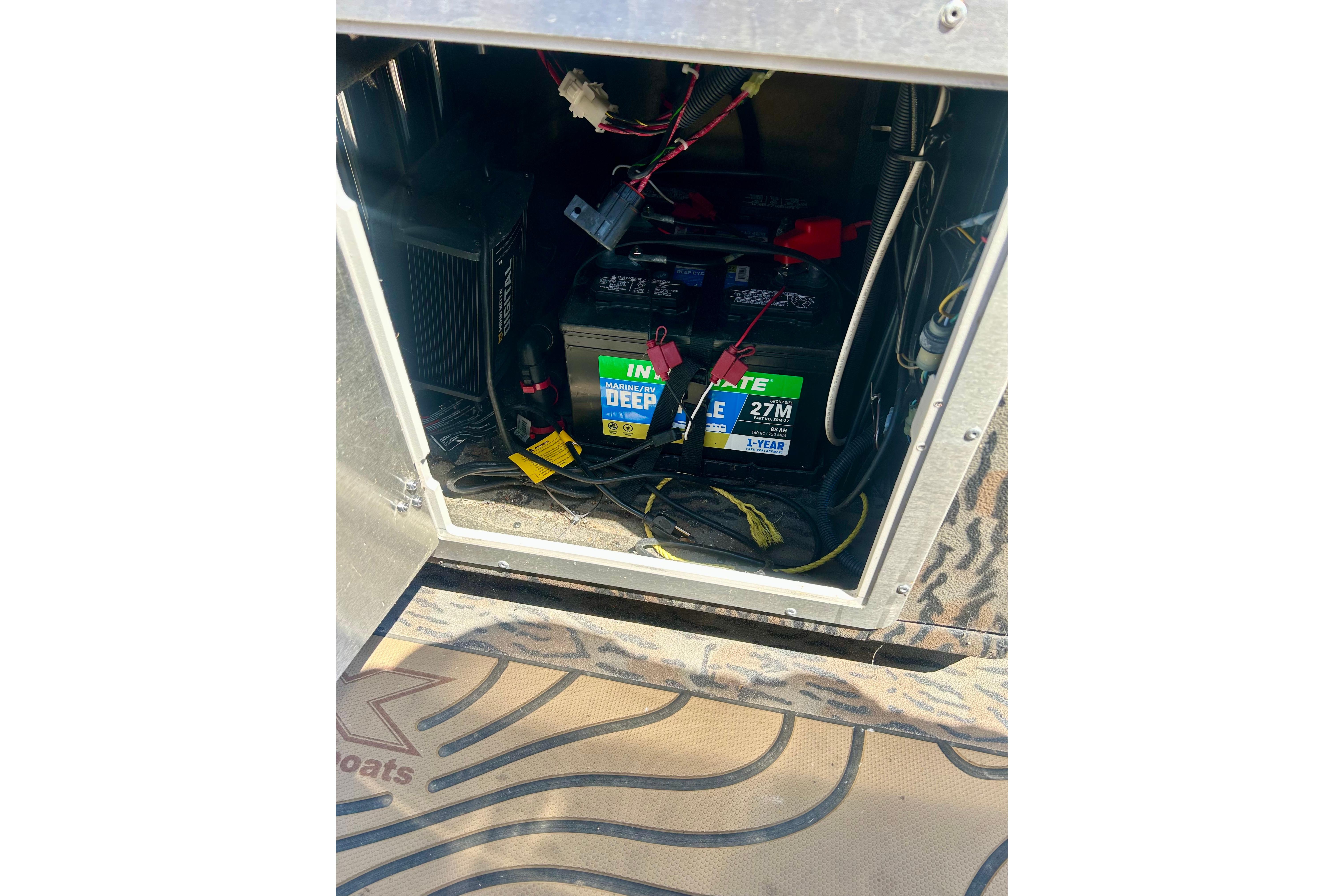 Battery compartment of 2025 Xpress H22B Bay boat, featuring marine deep cycle battery.