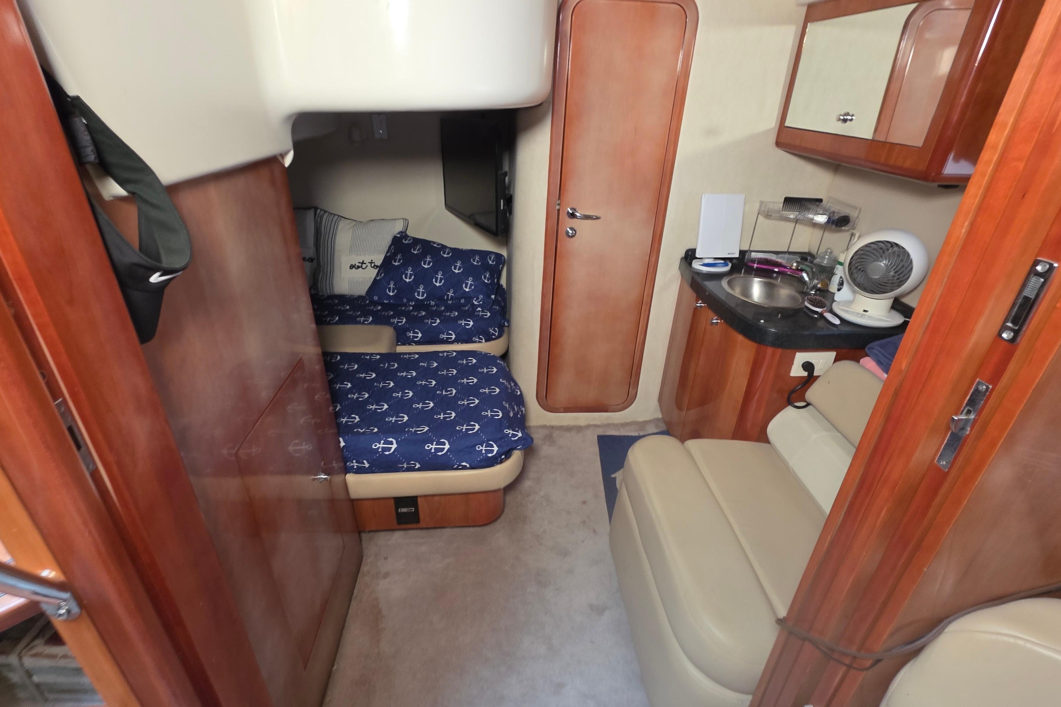 2002 Regal Commodore 4260 cabin interior with cozy beds and compact kitchenette.
