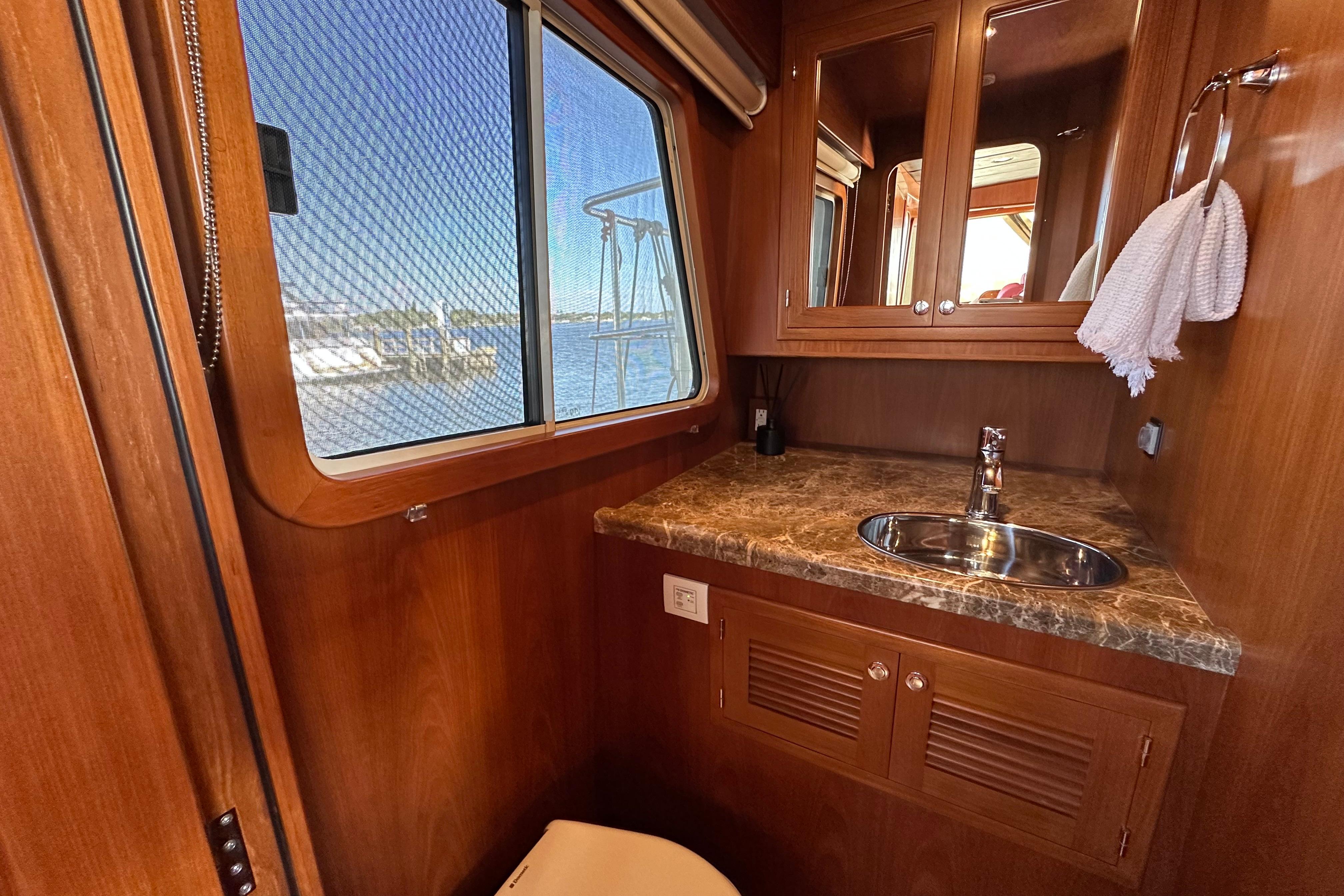 Luxurious 2017 Kadey-Krogen 58EB yacht bathroom with wood finish and marble countertop.