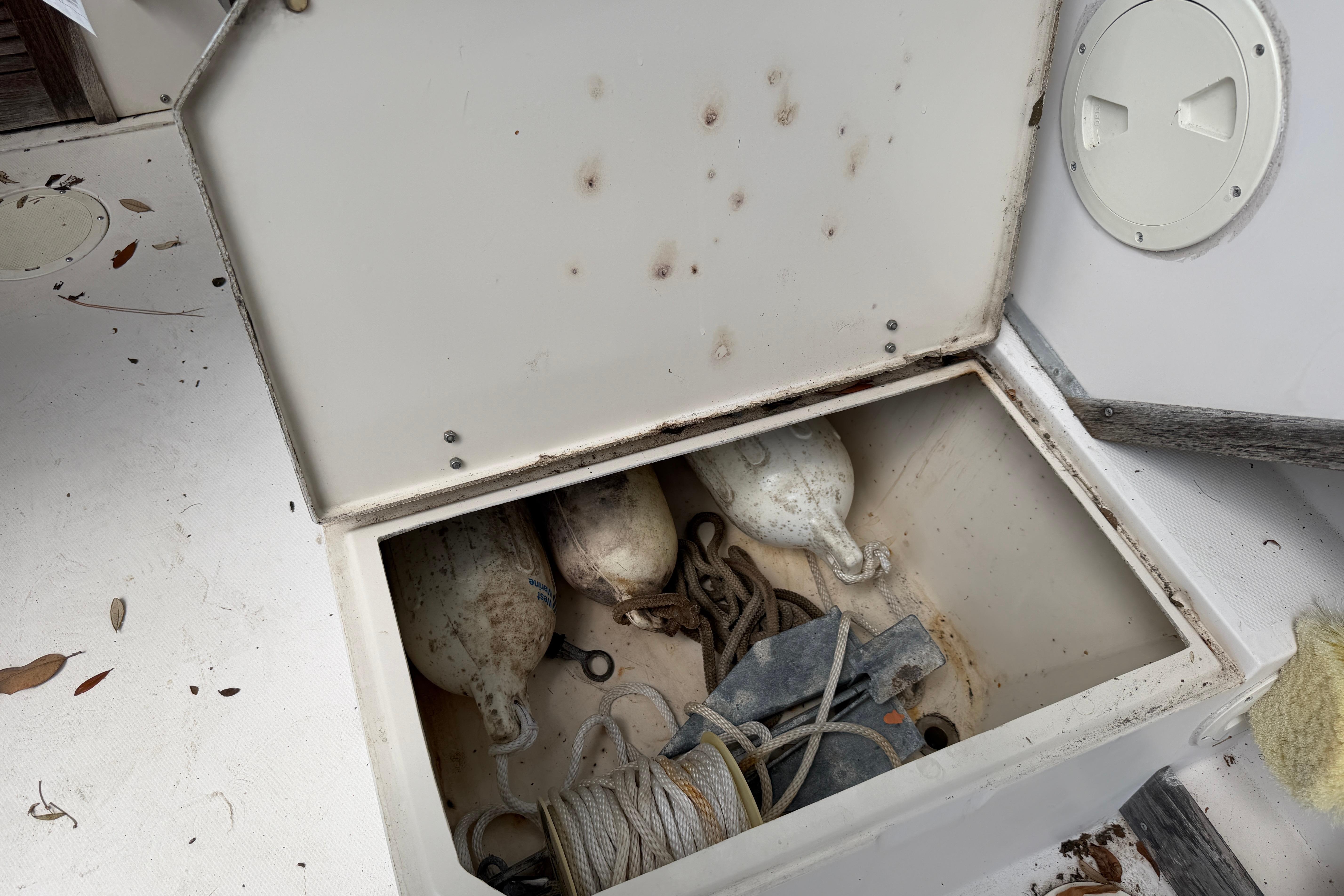 Open storage compartment on 1987 Grady-White Seafarer 226 boat with ropes and buoys.