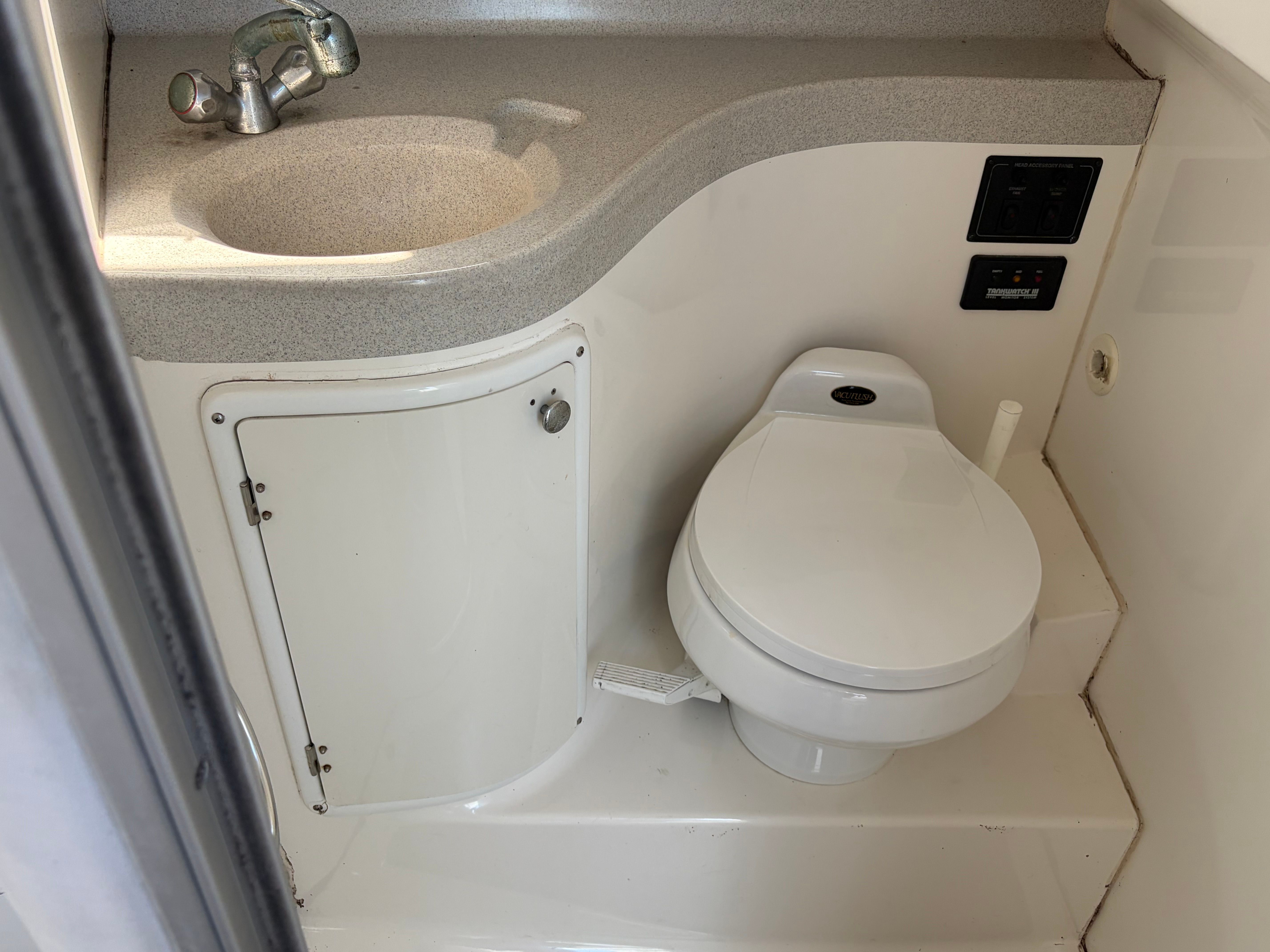 The image shows a boat bathroom with a toilet and a sink.