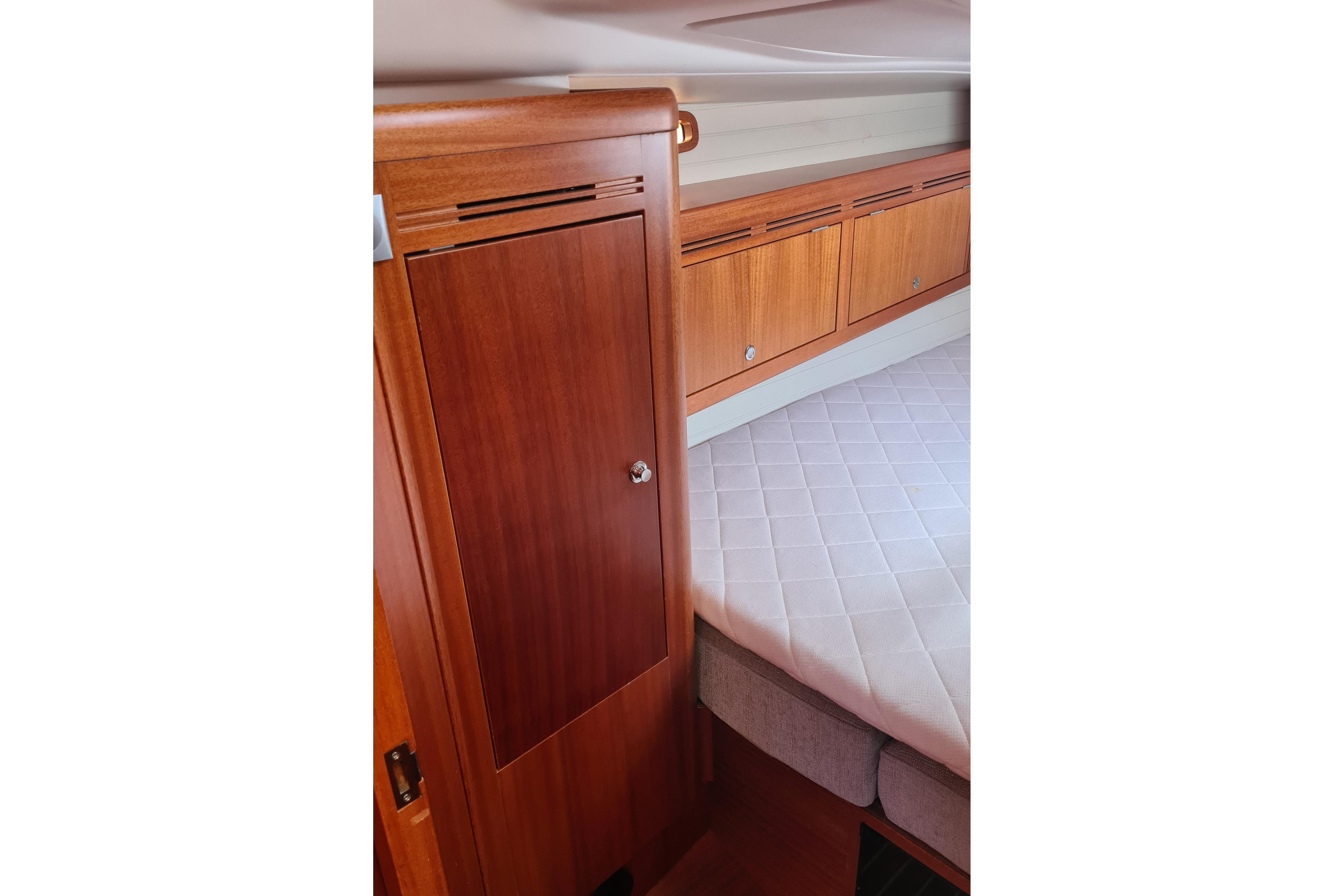 Interior of 2018 Arcona 435 yacht featuring wooden cabinetry and a cushioned bed.