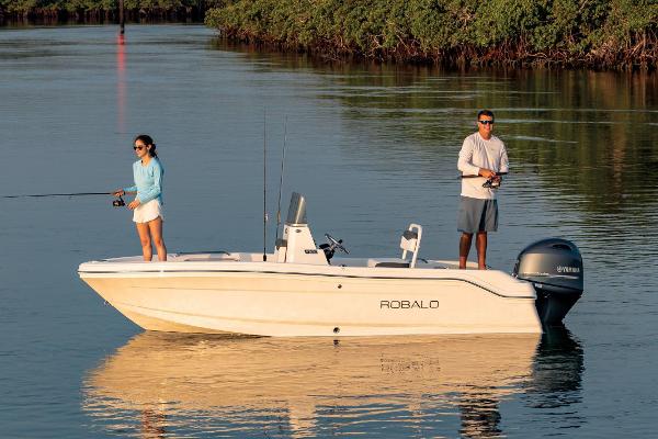 Manufacturer Provided Image: 2026 Robalo R160 Center Console boat with two people fishing on calm water.