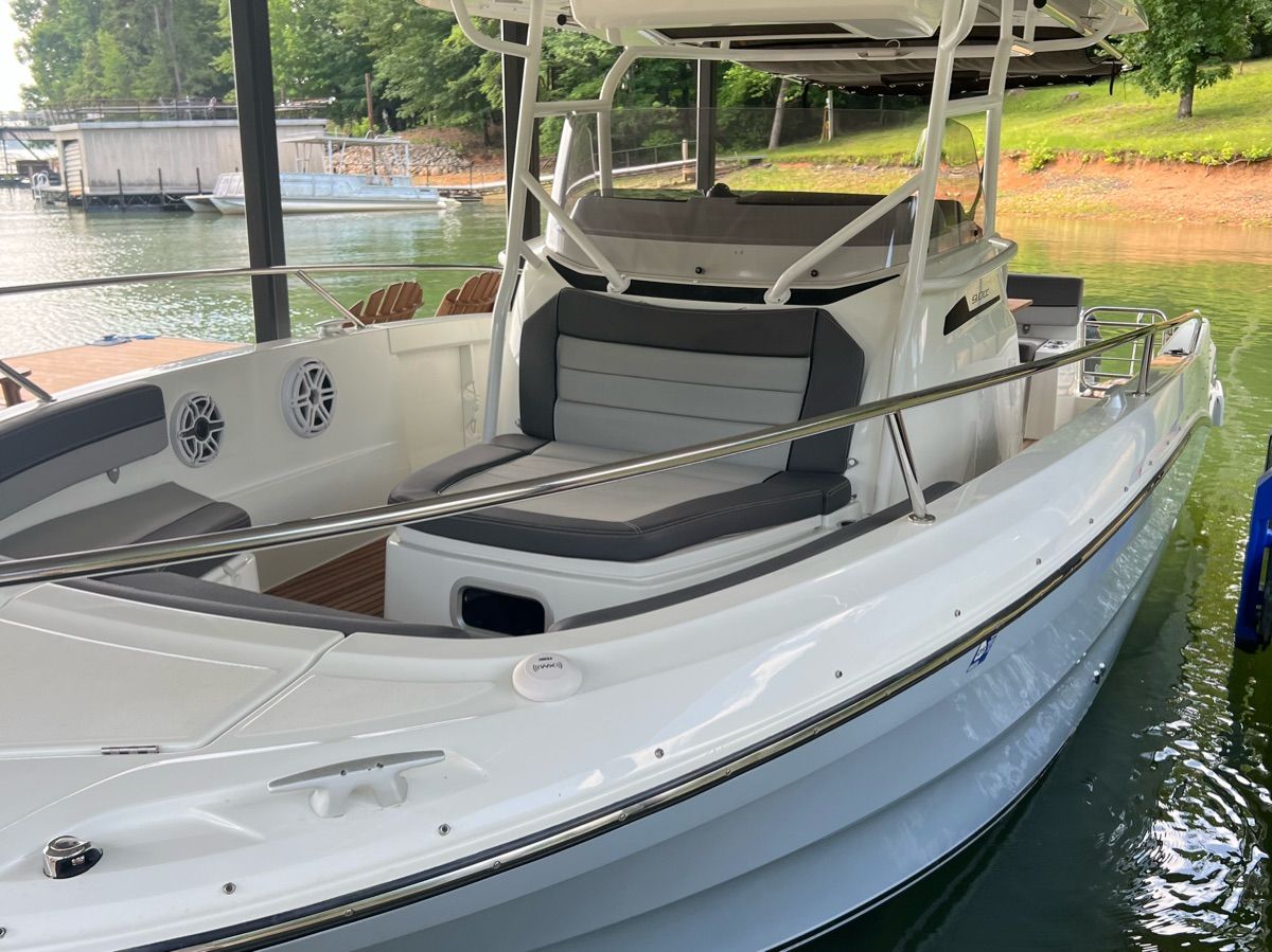 A 2020 Jeanneau Leader 9 is docked on the water. It features gray upholstery and a modern design.